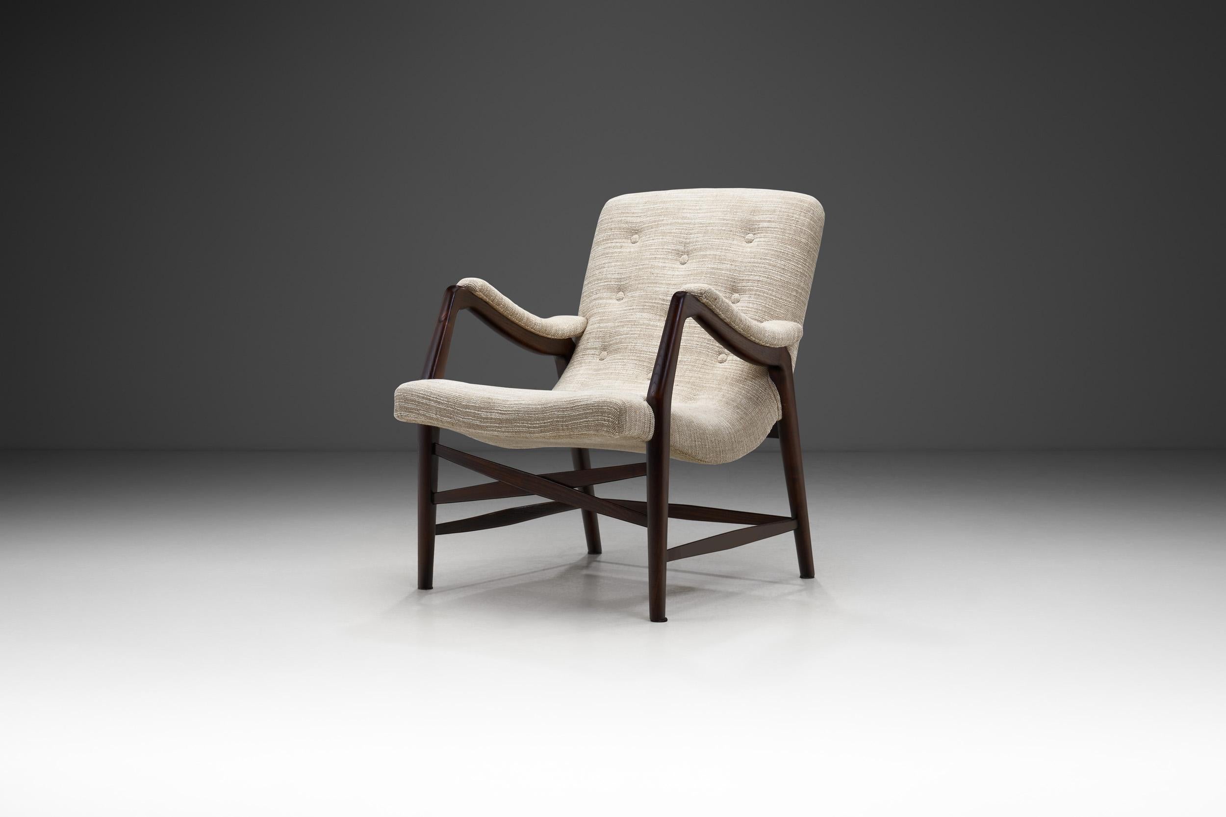 Este sillón fue diseñado en 1947 por Arne Hovmand-Olsen (1919-1989) para J. L. Møllers Møbelfabrik en Aarhus, Dinamarca. Es uno de los primeros diseños de Hovmand-Olsen y una de las primeras sillas que fabricó Niels Otto Møller, fundador de J.L.