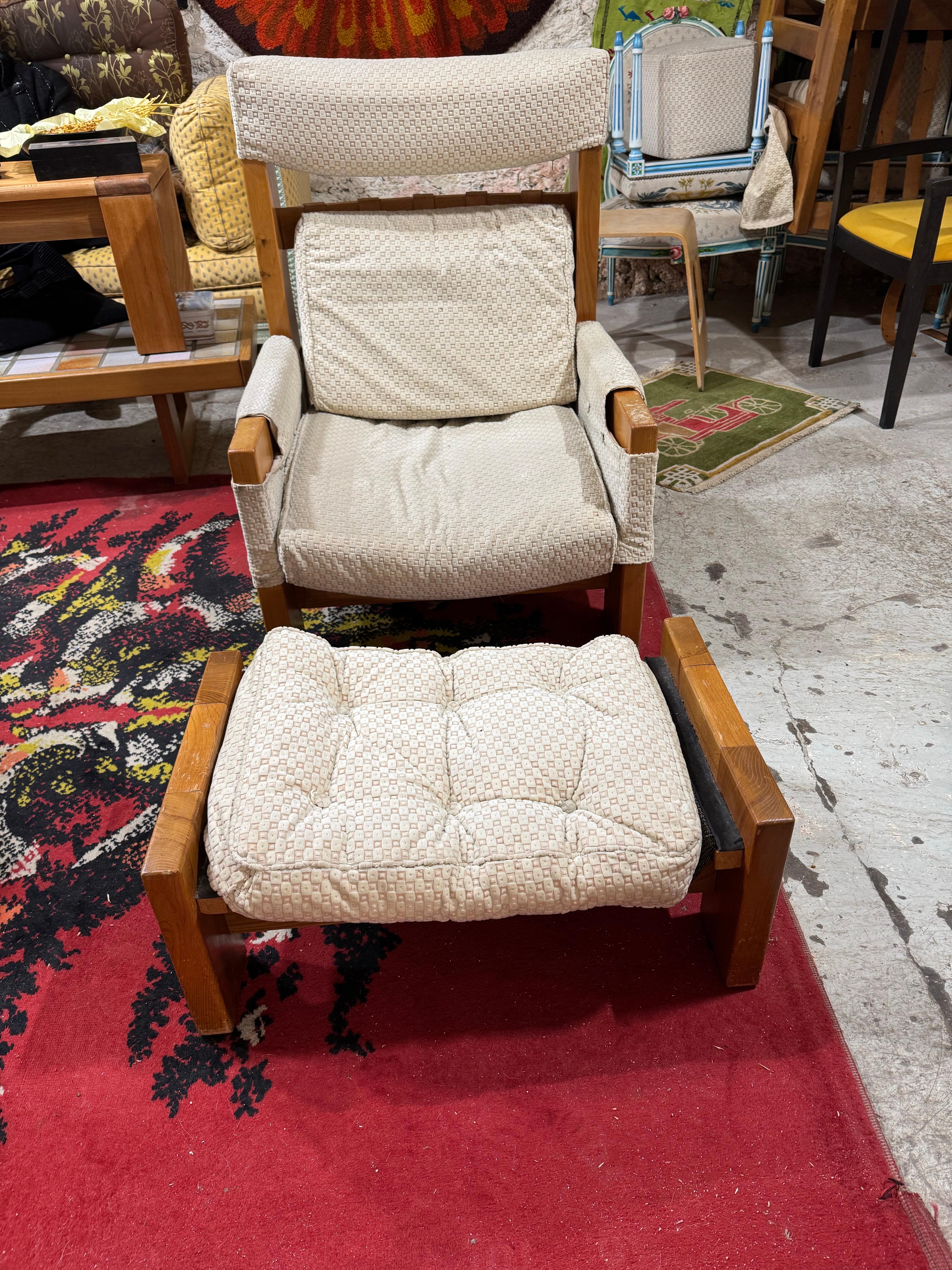 Un fauteuil iconique de la Maison Regain en orme massif avec son ottoman assorti.