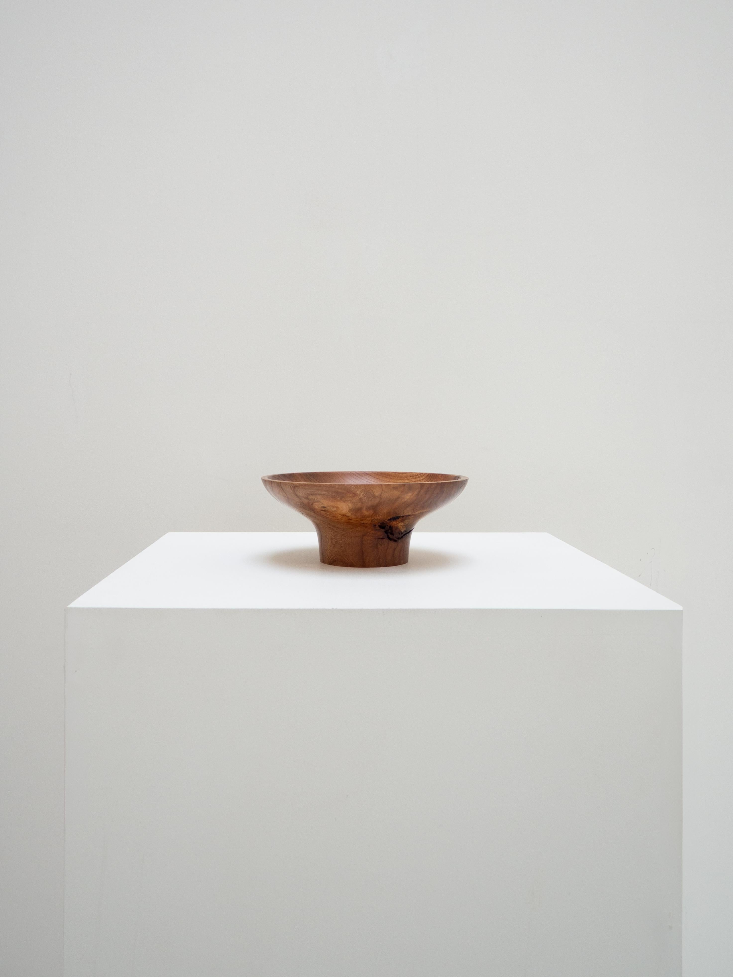 Crafted by the English workshop Bird and Branch, this elm bowl is the result of a long-shelved wood, which finally found its ideal form, inspired by Japanese aesthetics. Its raised silhouette allowed the wood's cracks to be diverted while revealing