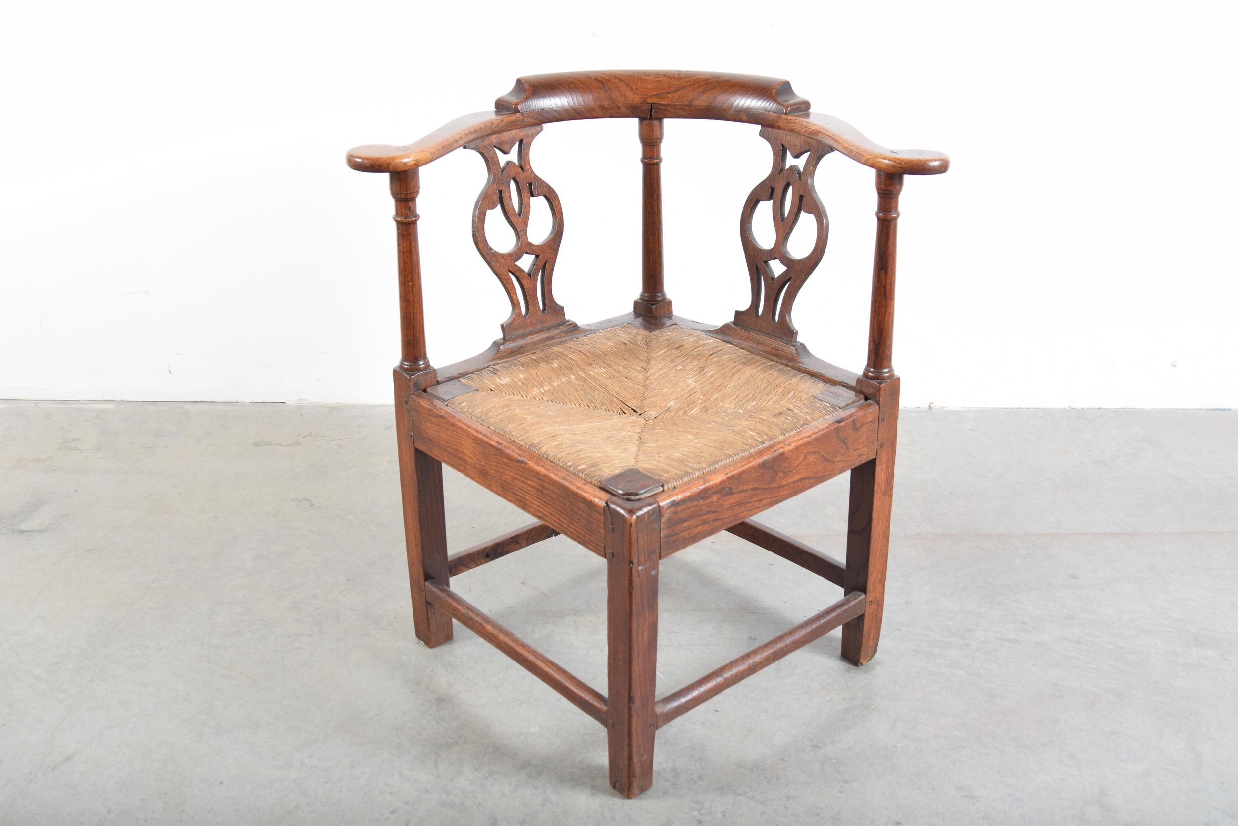 Elm Chippendale corner chair with rush seat, circa 1780-1820. Most likely English. As with many pieces of this age, there have been some repairs over the years. Most notably, a few of the original square pegs have been replaced with round pegs.