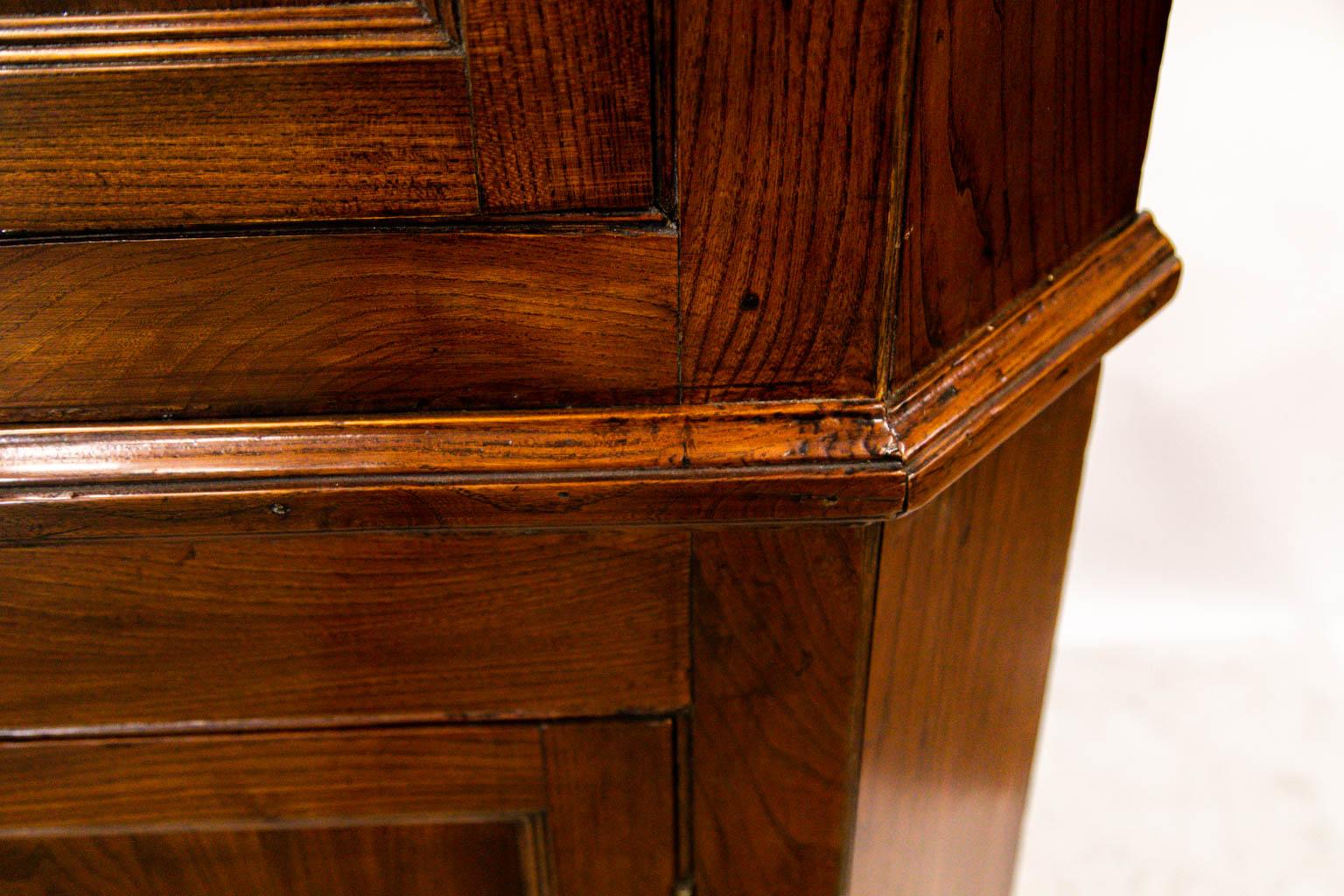 Beautiful elm corner cupboard, the interior with ''butterfly'' shaped shelves.  The feet, backboards, and hardware of this English cupboard have been restored.