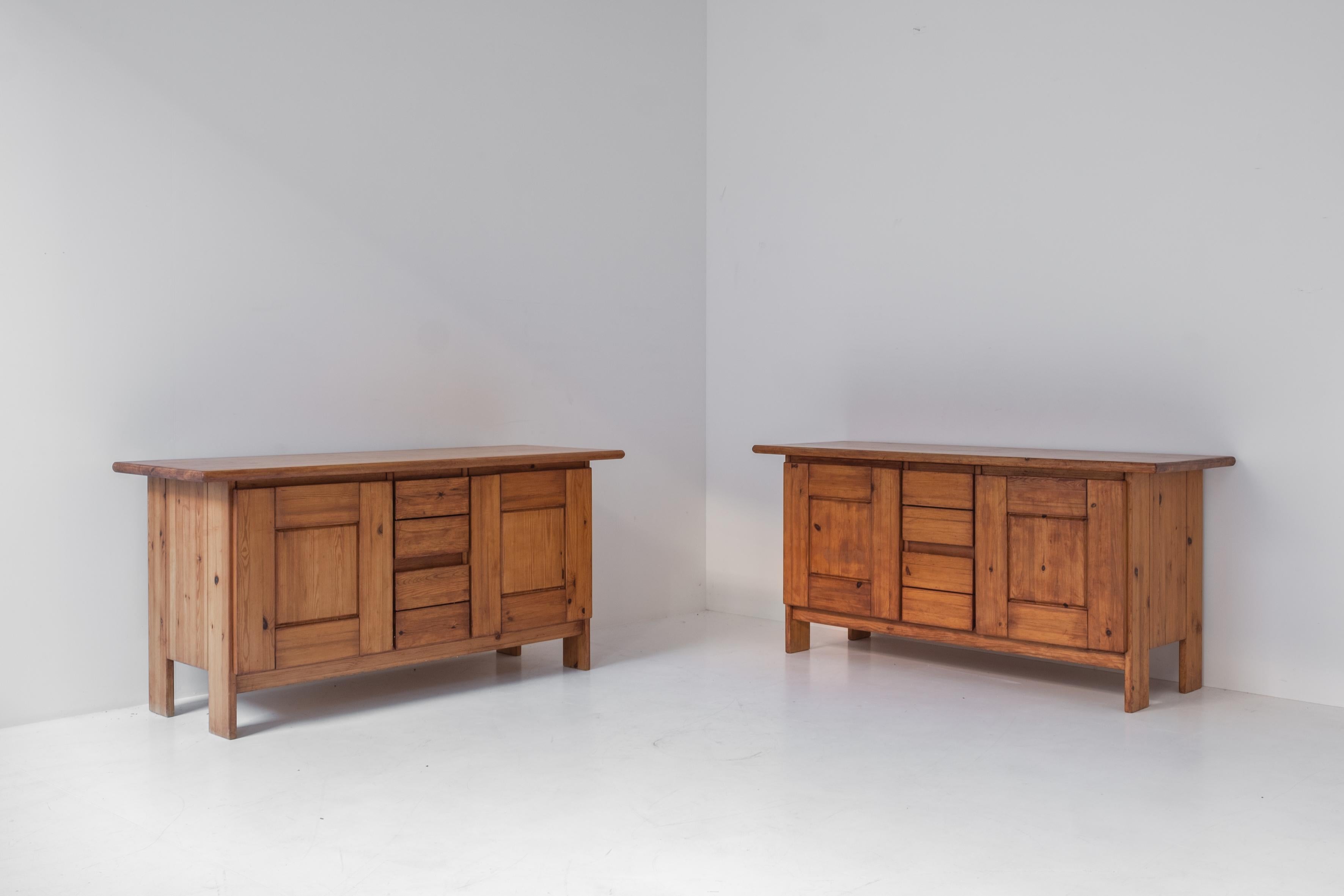 Great pair of sideboards designed and manufactured in France, dating from the 1960s. This identical set is made out of solid elm and features an open storage area on the left and right of the middle drawer section. Both cabinets are in its original