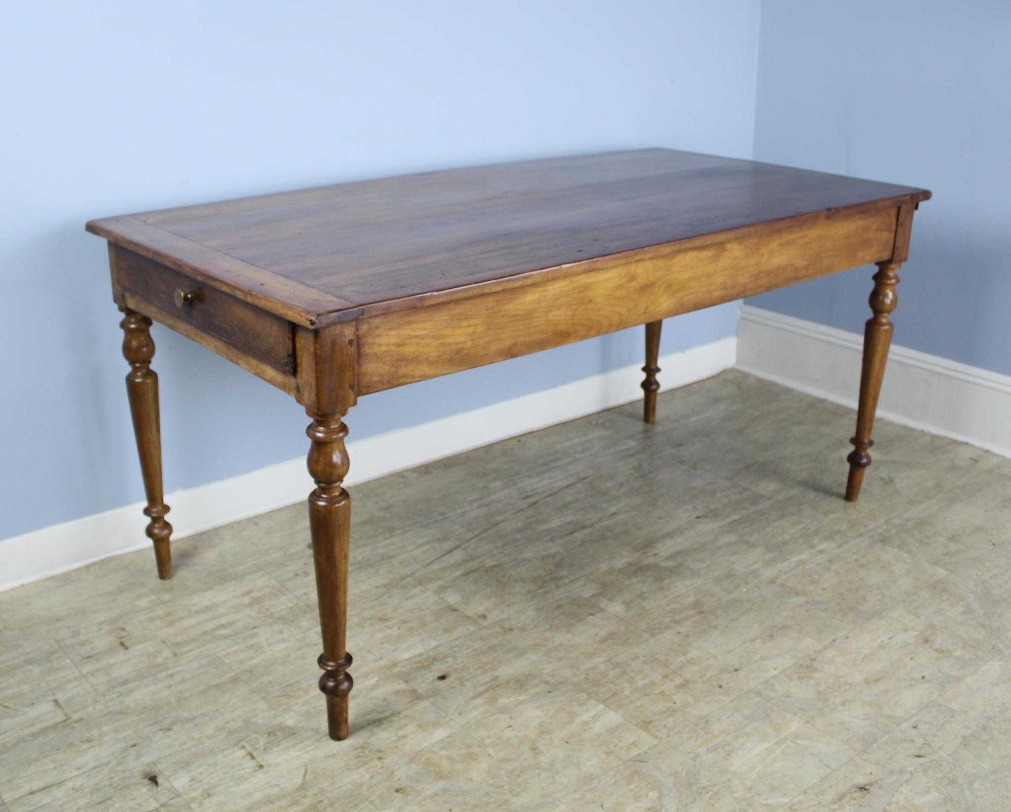 A smaller elm farm table with glossy turned legs and a gently refinished top with breadboard ends. Single roomy drawer at one end and bread slide at the other. Bread slide is in good condition and sturdy enough for additional diners or serving