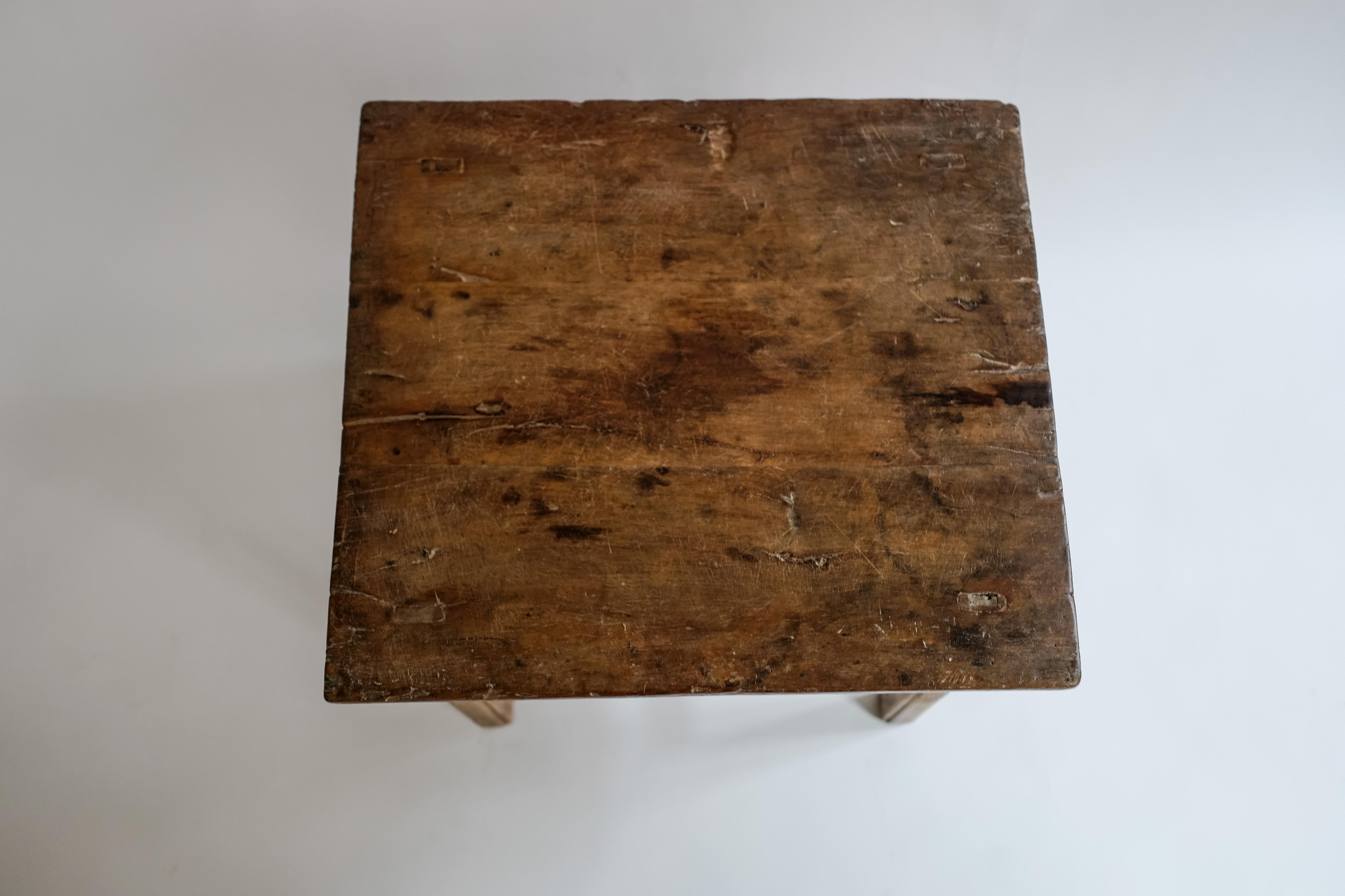 A handcrafted elm wood side table made in China circa 19th century. Solid single piece of wood used for the top. Beautiful rustic feel.