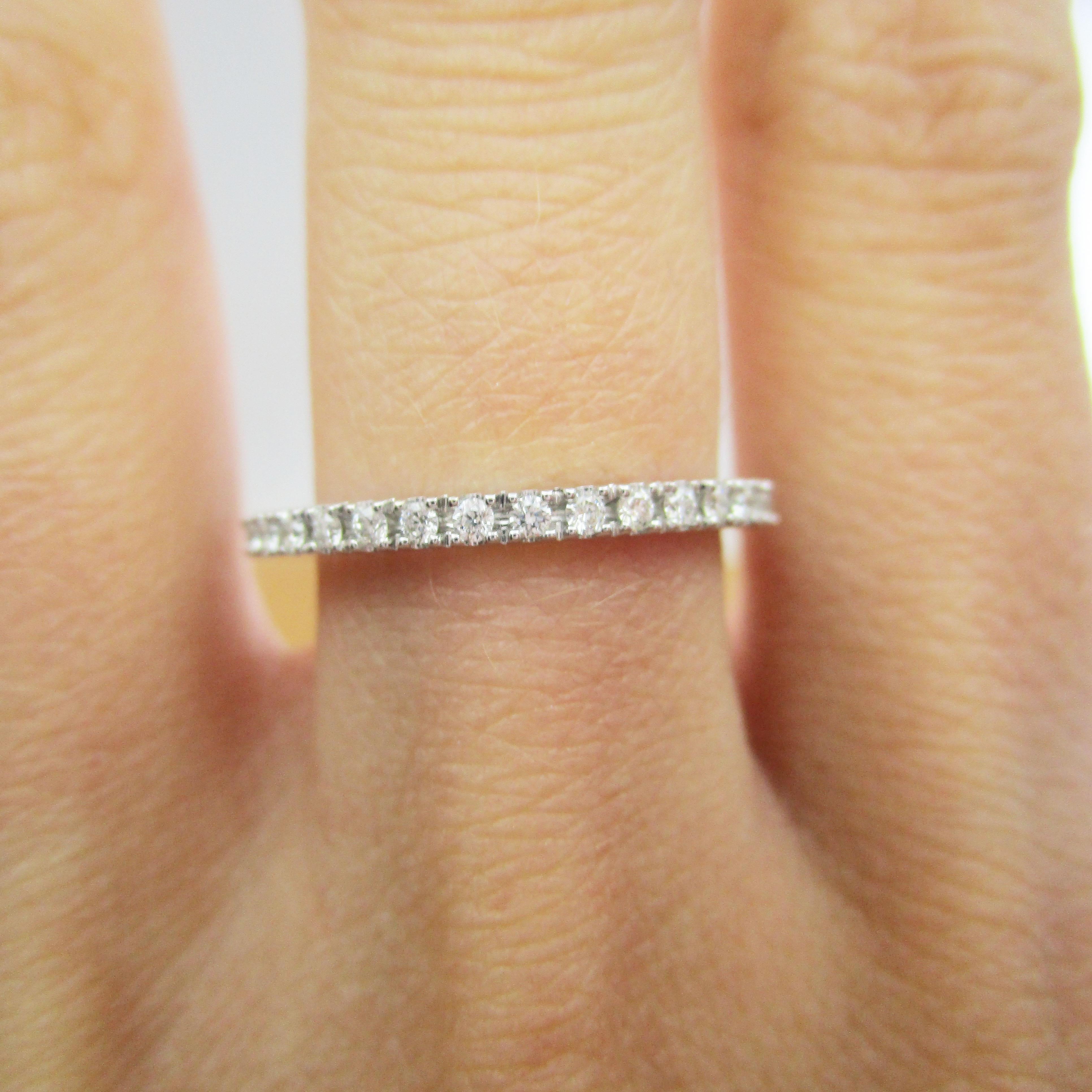 This gorgeous band by Elma Gil is in 18k white gold and has a beautiful array of brilliant white diamonds set into half of the band. The elegant simplicity of this band means that it is the ideal stacking band! This ring would also make a stunning