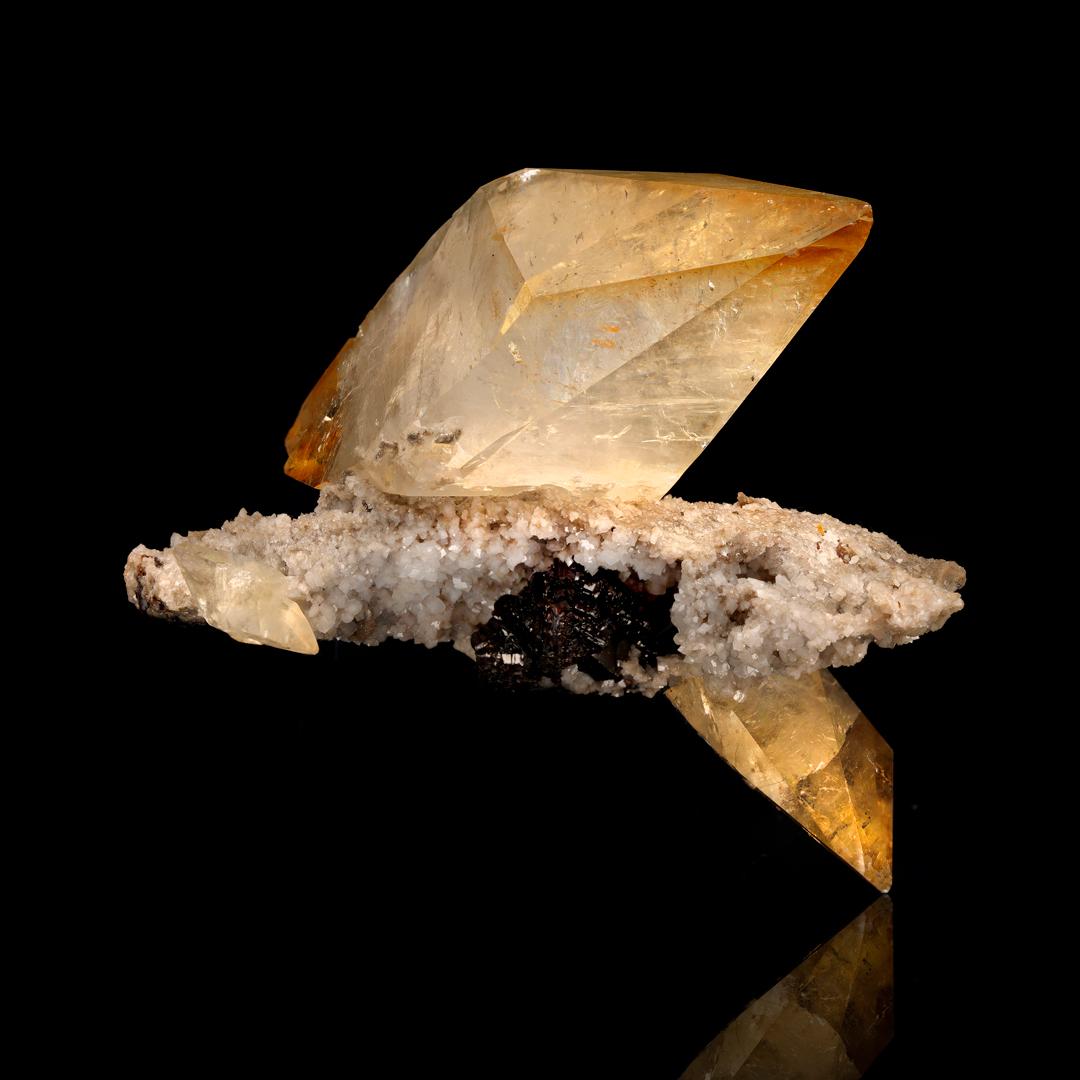 These large, sharply defined, beautifully formed golden calcite crystals out of the famed calcite mine in Elmwood, Tennessee heave beautiful golden pigmentation especially toward the well terminated points. The larger of the crystals is double