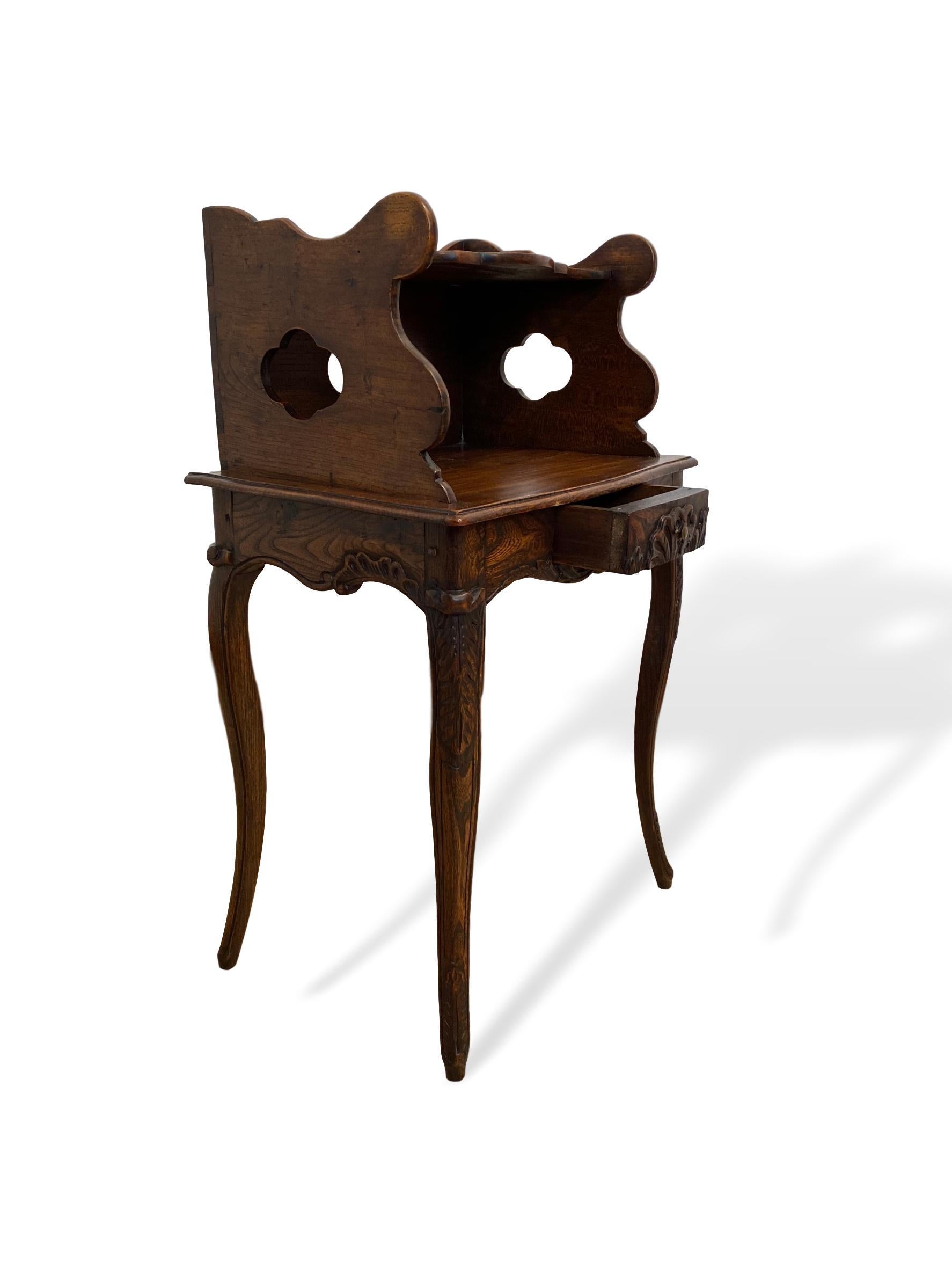 Highly figured elmwood side table with gallery/shelf, pierced quatrefoils, French, circa 1870, with a single drawer, hand carved with a freestyle shell to the drawer and apron, with hand carved acanthus leaf decoration to the shaped cabriole legs.