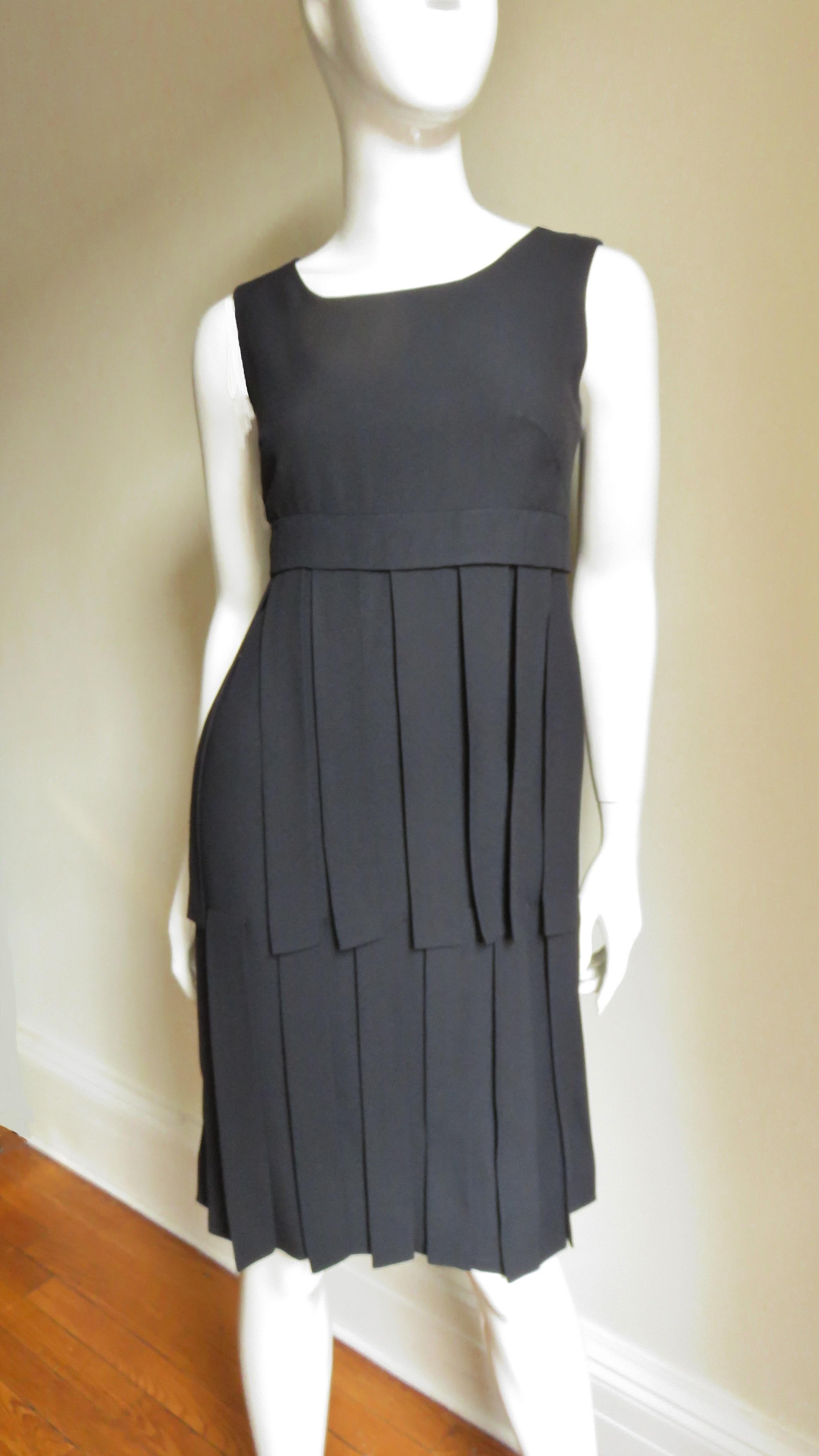 Ein bezauberndes schwarzes Kleid von Eloise Curtis.  Es handelt sich um ein ärmelloses Kleid mit Rundhalsausschnitt und 2 Reihen von 12-Zoll-Stoffbahnen, die von einem Band knapp unter der Brustlinie ausgehen, und einer Reihe von 14-Zoll-Bahnen