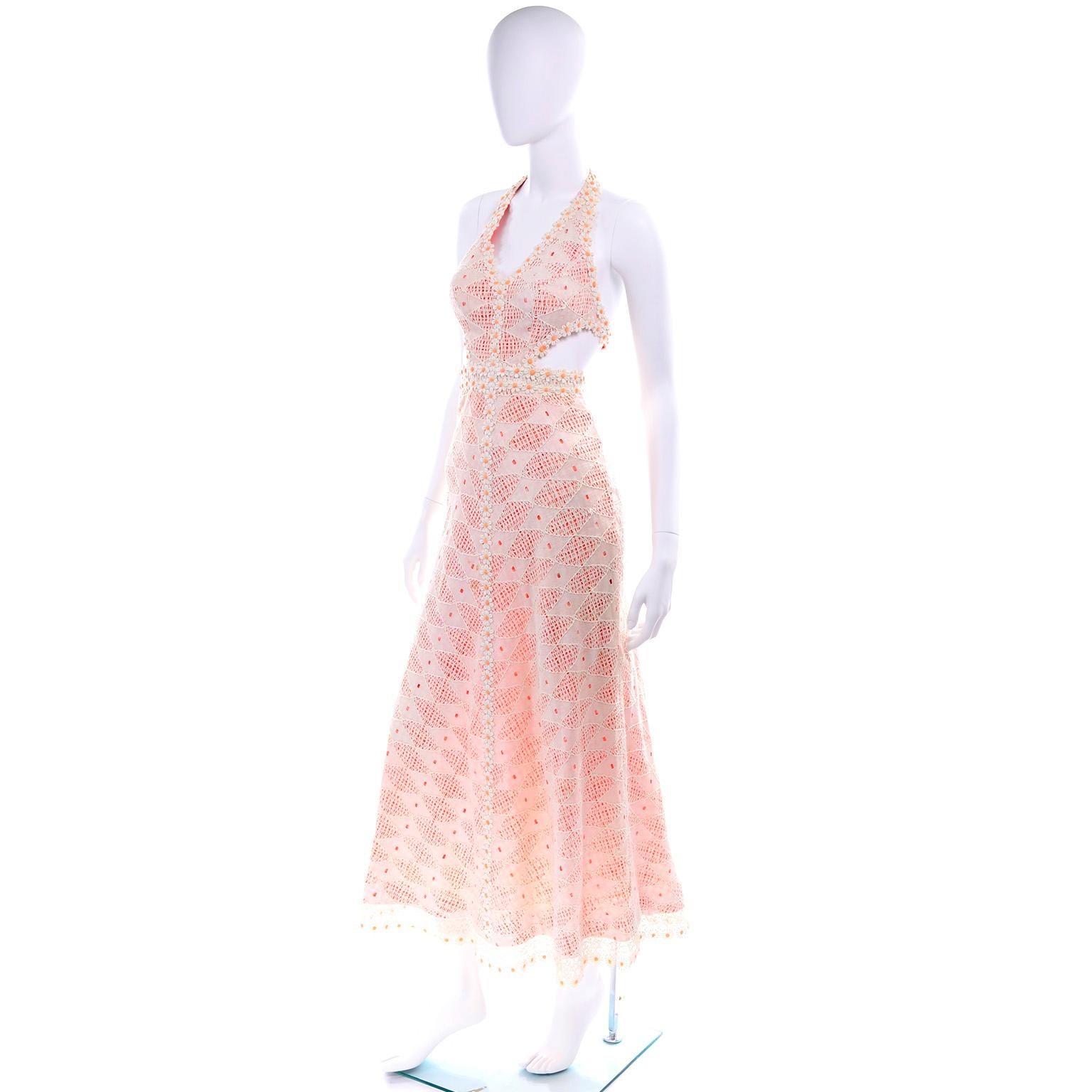 This is a really fun vintage 1970's halter dress in orange and white gingham with crochet lace overlay.  We love the cut outs at the waist and the daisy appliques. The dress closes with a back zipper and hooks and eyes.  There is a pretty daisy lace