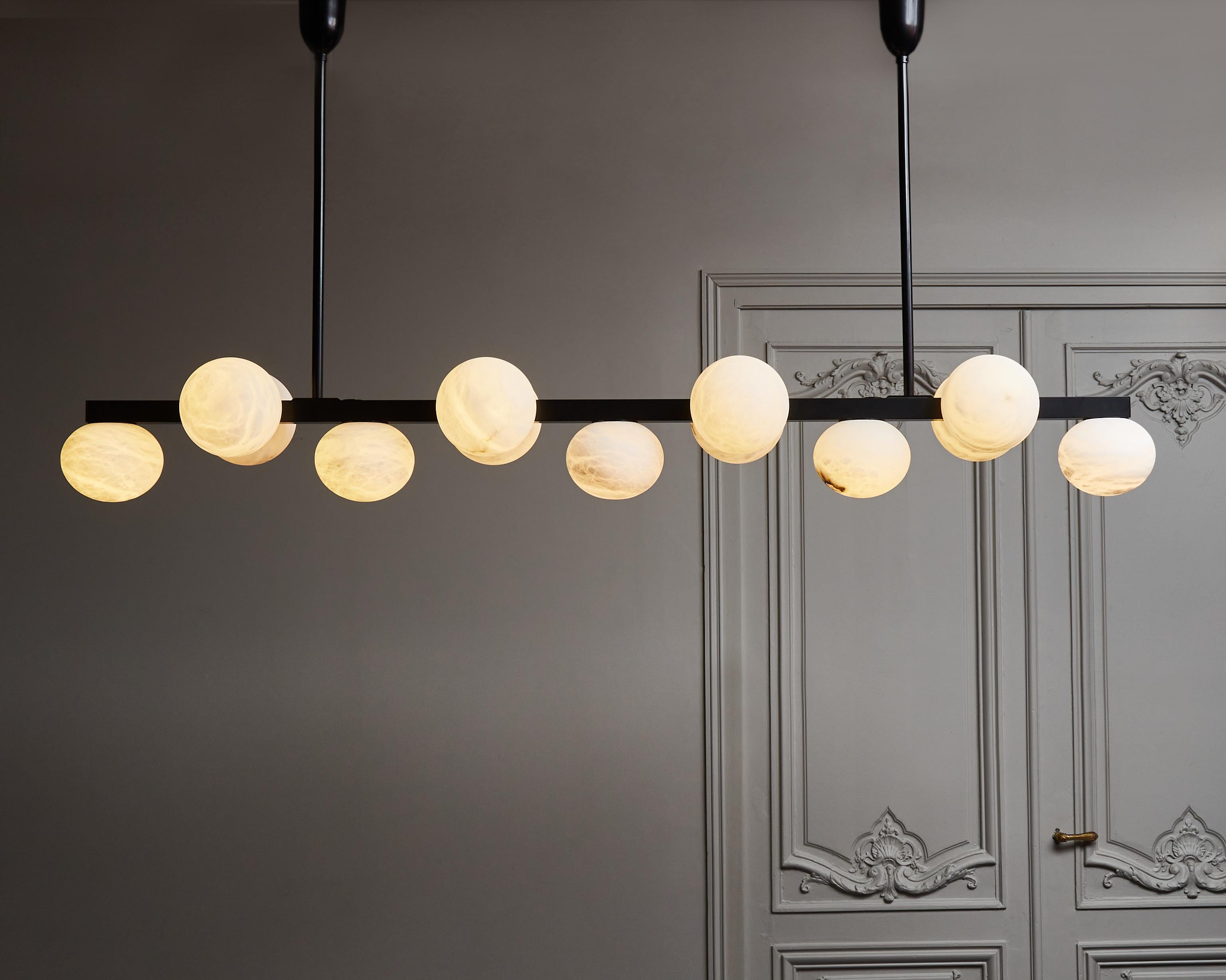 Long chandelier made of a rectangular brass center stem with flattened alabaster globes on its three sides. Shown here in mat black finish.