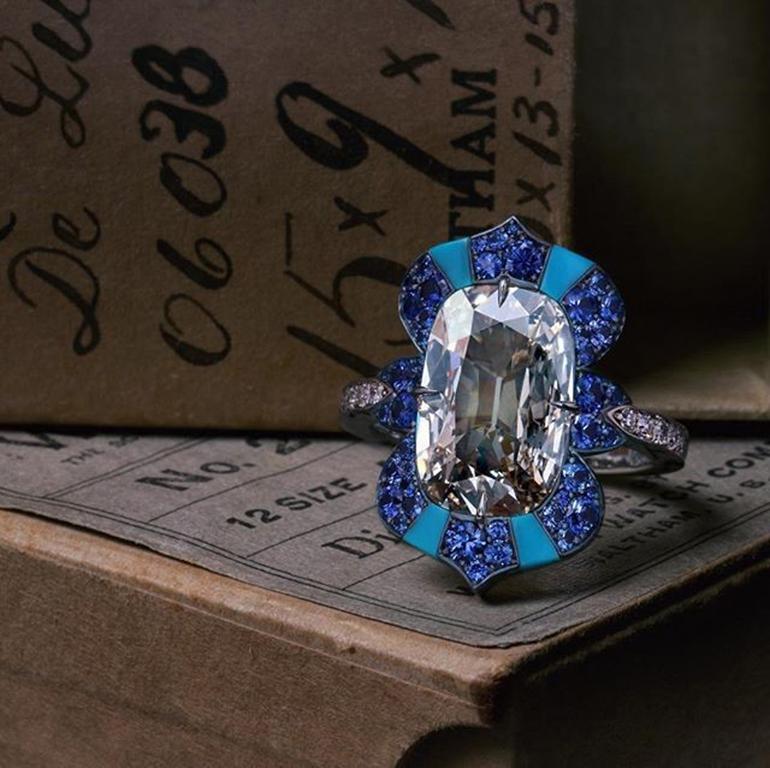 Fine handmade cocktail ring, centering an antique-cut elongated cushion-shaped diamond weighing 4.01 carats, framed by round-cut sapphires and four inlaid wedge-shaped Sleeping Beauty turquoise, the shank further accented with pave single-cut