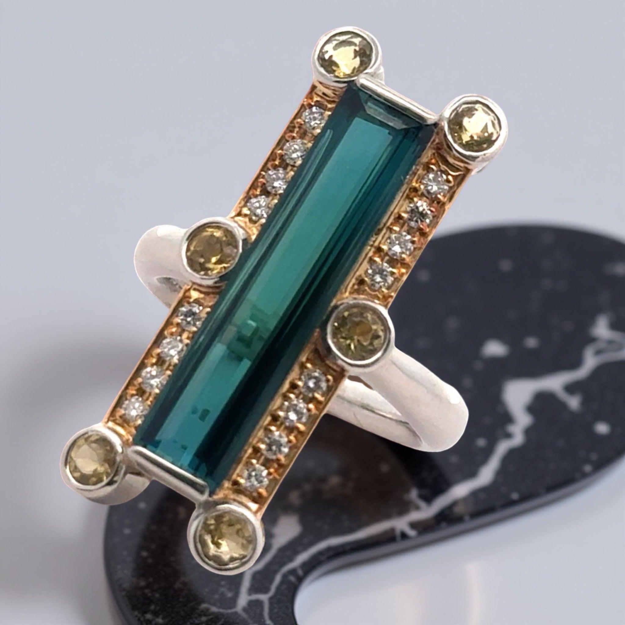 Cette bague unique en son genre en forme de tourmaline verte allongée présente une combinaison étonnante de diamants et de citrine sertis dans du platine et de l'or jaune 18 carats. Avec son design unique, cette bague vintage ne manquera pas de
