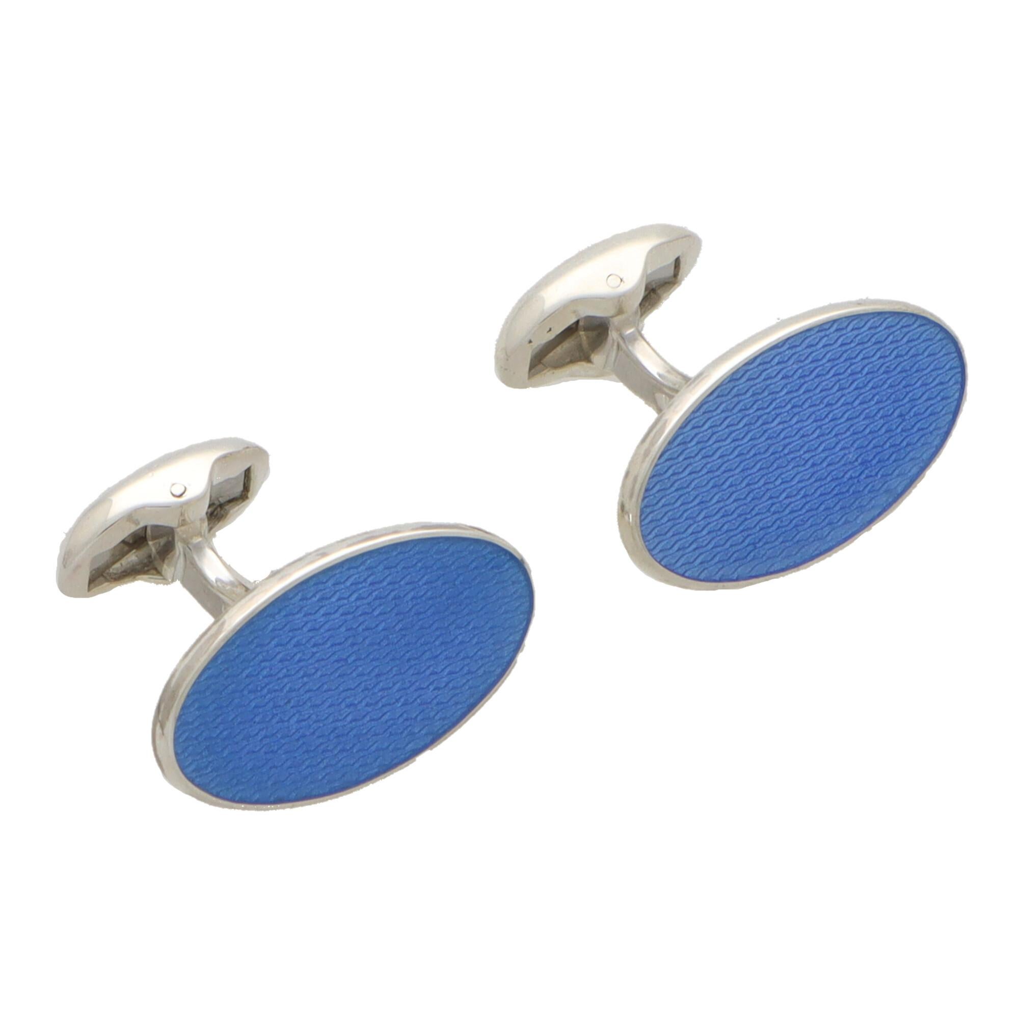  An extremely striking pair of blue elongated oval swivel back cufflinks made in British sterling silver.

Each cufflink is composed of two elongated oval faces set with textured light blue enamel. They are secured to reverse with a swivel back