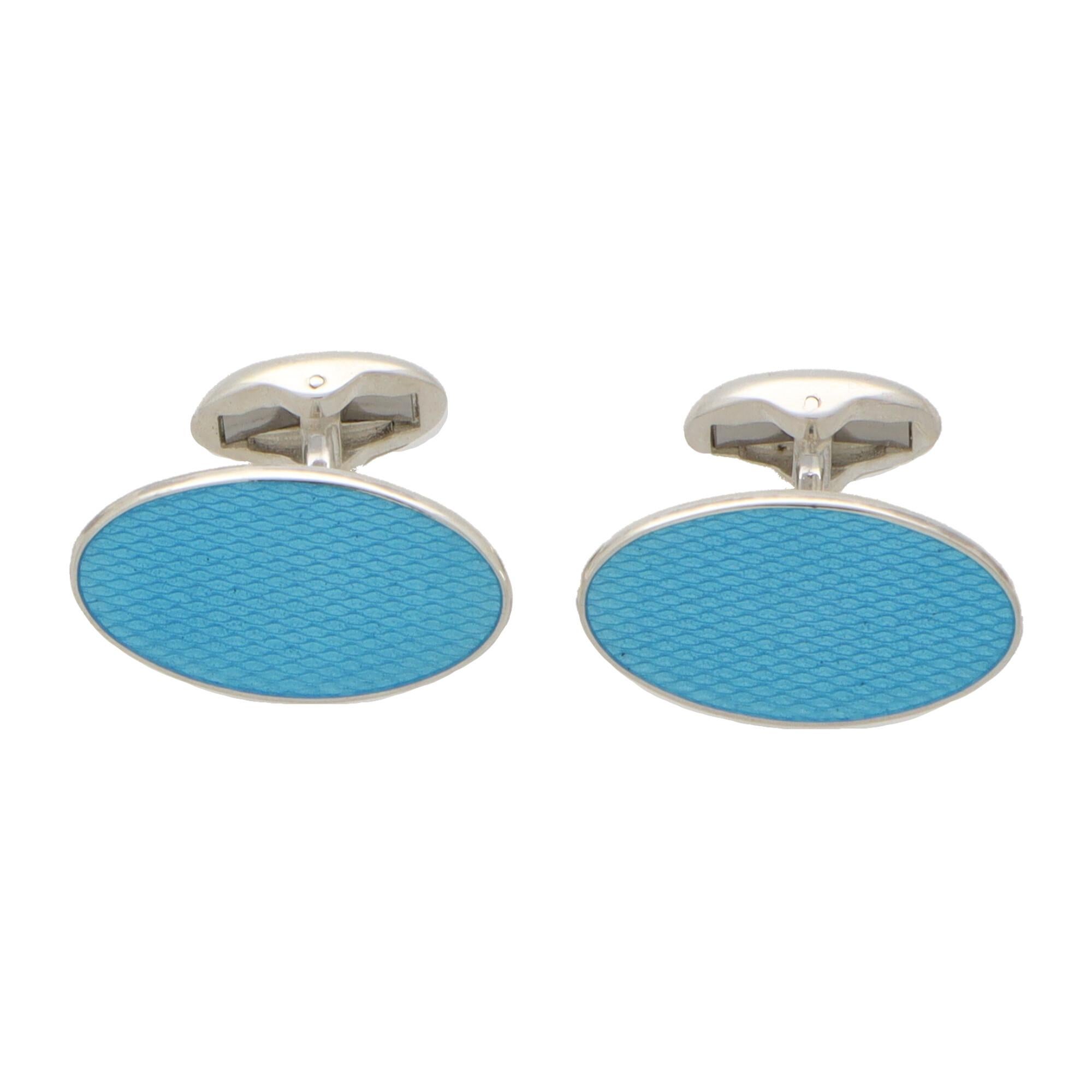 An extremely striking pair of turquoise elongated oval swivel back cufflinks made in British sterling silver.

Each cufflink is composed of two elongated oval faces set with textured turquoise blue enamel. They are secured to reverse with a swivel