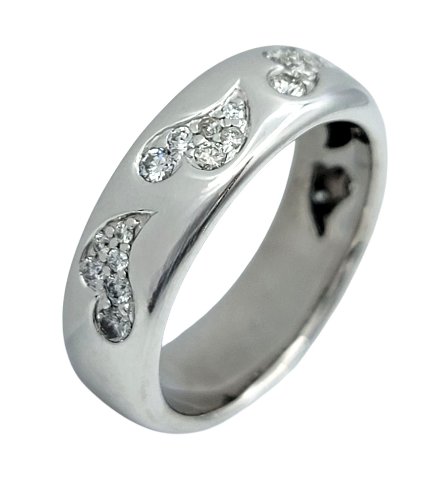 Misura dell'anello: 6,75

Questo anello a fascia con diamanti scintillanti presenta un design abbagliante con motivi di cuori allungati e danzanti, ognuno dei quali è ornato da pavé di diamanti tondi e brillanti. I cuori sono delicatamente