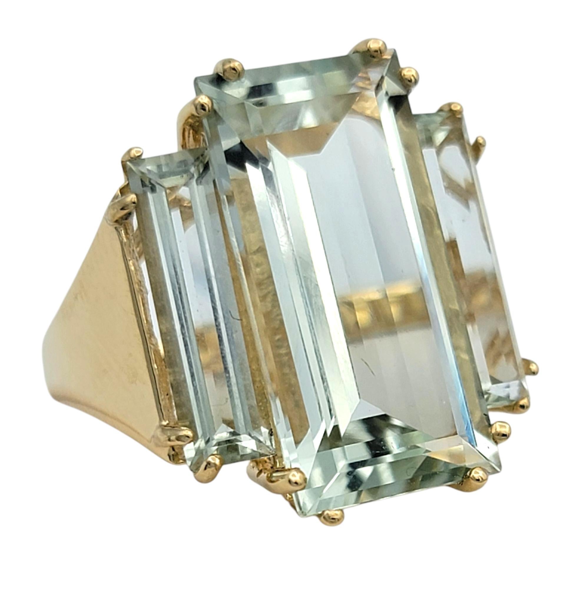 Misura dell'anello: 7

Questo anello con prasiolite è caratterizzato da un trio di pietre rettangolari allungate di colore verde chiaro che creano un profilo audace e architettonico. La prasiolite centrale è incastonata verticalmente, accentuata da