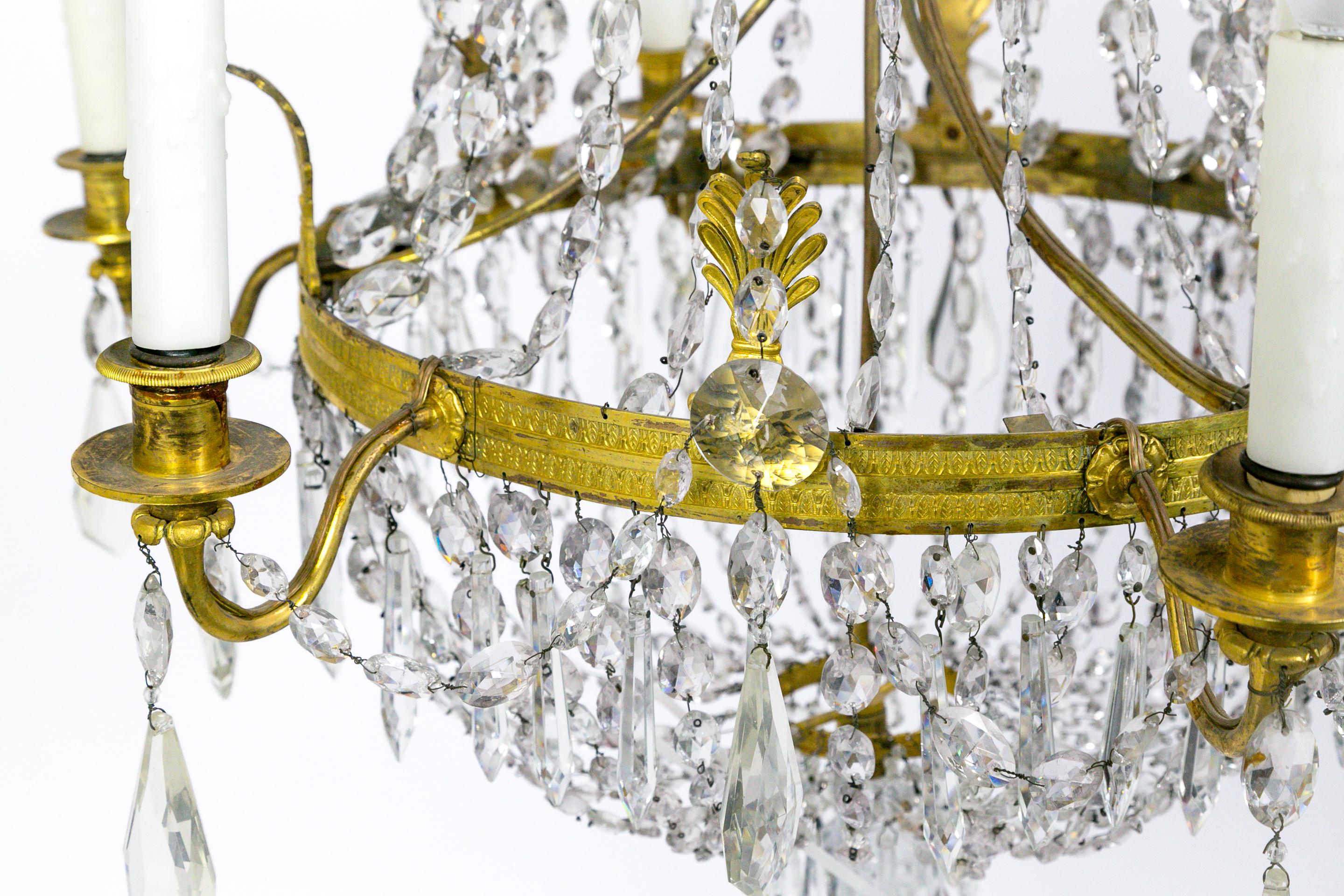 This Regency, tent and bag style, crystal chandelier has lovely brass fleurets, and crystal ropes, swags, and pendants; forming an elegant, elongated appearance. American, circa 1920s. Measures: 25