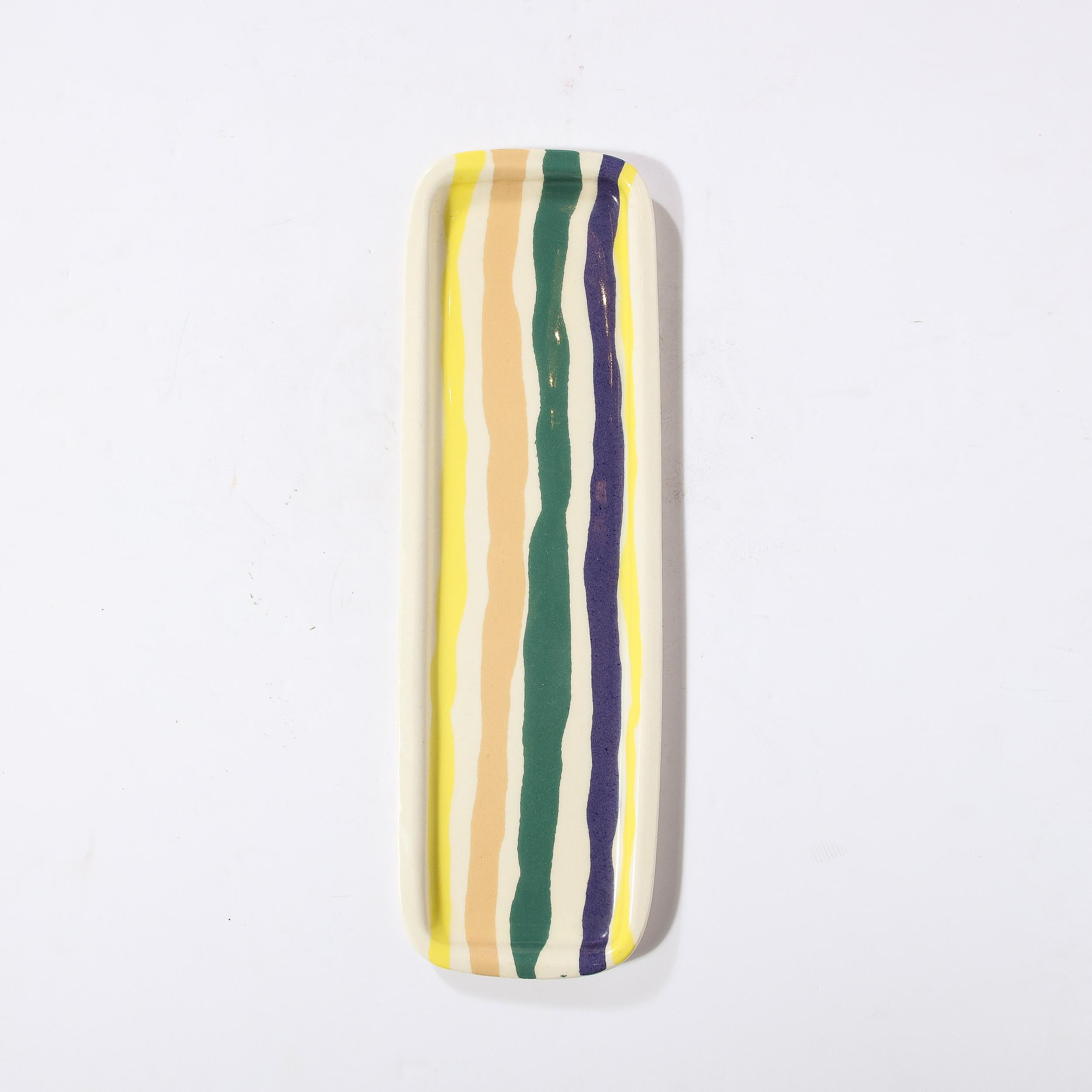 This beautiful elongated modernist serving platter was realized by the esteemed artist Jurg Lanrein in Switzerland during the latter half of the 20th century. It offers a rectangular form with raised sides and hand embellished organic striations