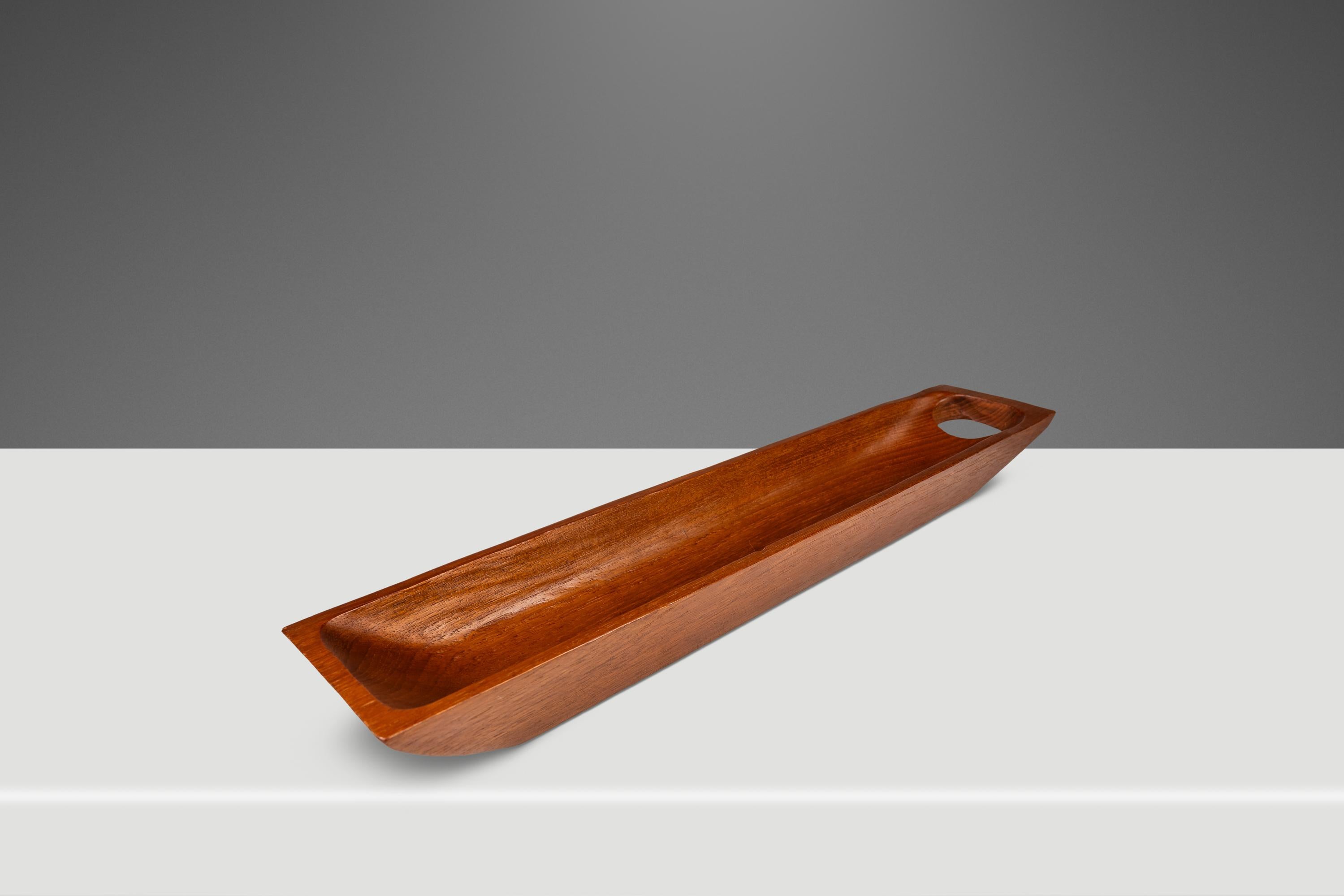 Introducing a quintessentially Organic Modern catch-all tray hand-carved from a solid slab of Burmese teak. Replete with exquisite variegated woodgrains unique to the teak species this extra long serving tray is as functional as it is aesthetically