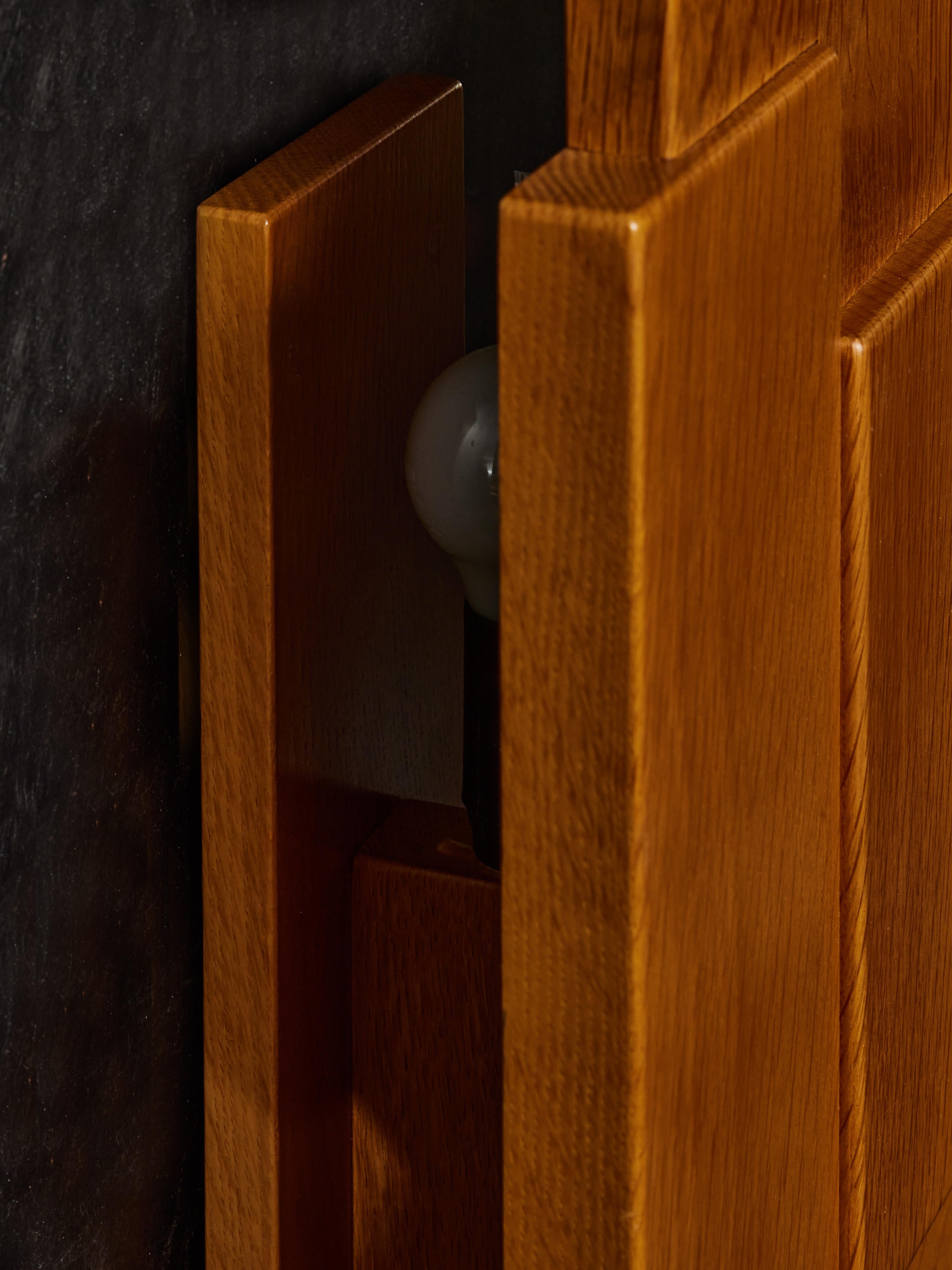 Minimalist teak wall sconce, offset from the wall with two sources of light.