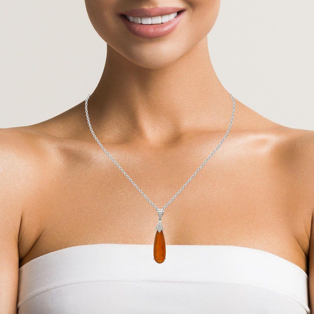 This vibrant Teardrop Fire Opal and diamond pendant is set in 14 karat white gold. This stone is over 8 cts in weight and has a basket setting with 25 sparkling brilliant cutn diamonds for a beautiful accent. This pendant is over 4 cm in length and