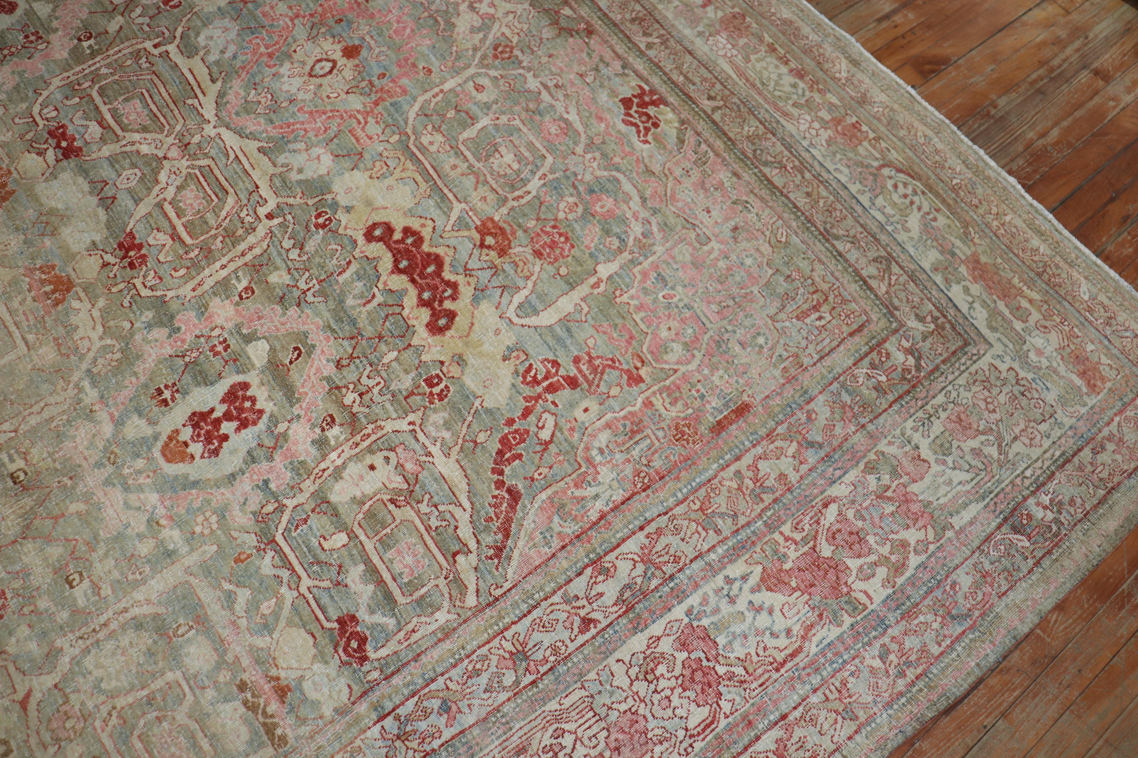 An early 20th century Persian Bidjar rug with a feminine motif with pink and rose accents on a grayish green striated field

Measures: 10'9