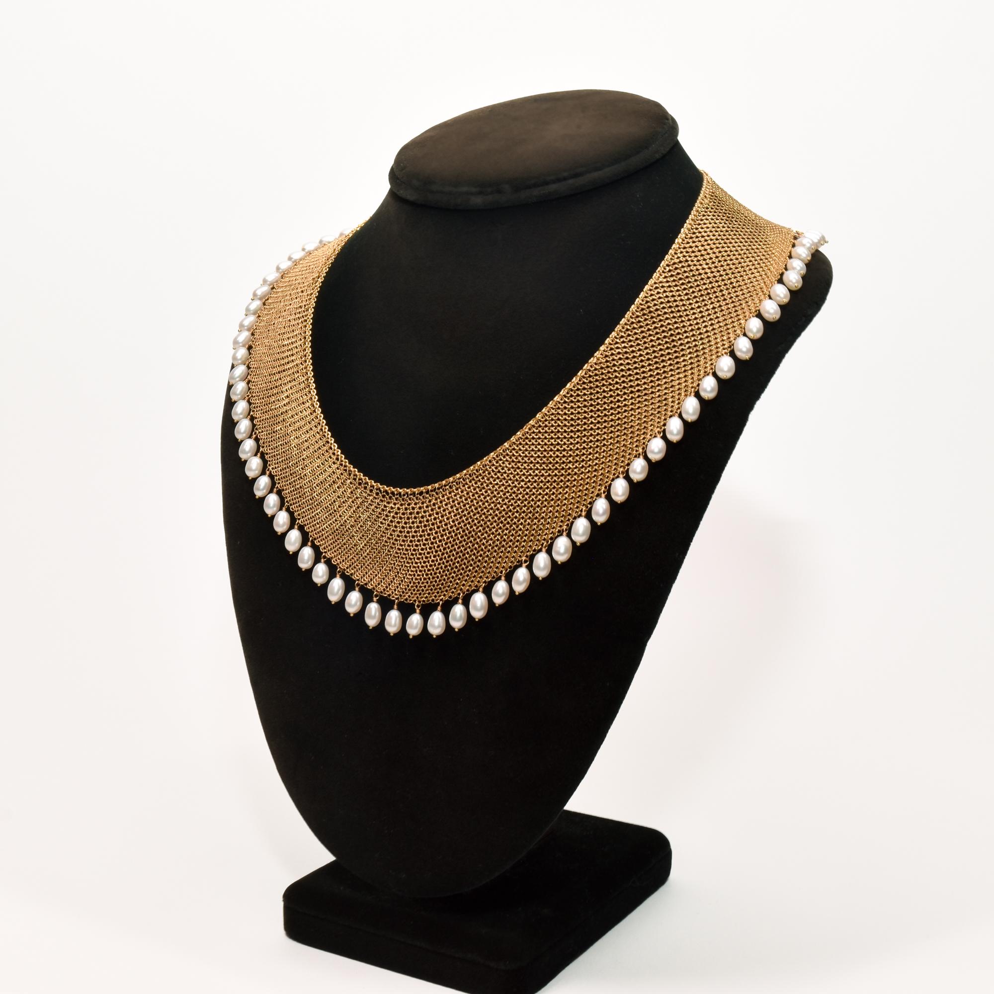 A breathtaking 18K yellow gold mesh pearl bib necklace designed by Elsa Peretti for Tiffany & Co. Features a stunning chainmail collar detailed with a fringe of 57 pearls. The necklace drapes beautifully along the decolletage and secures with an