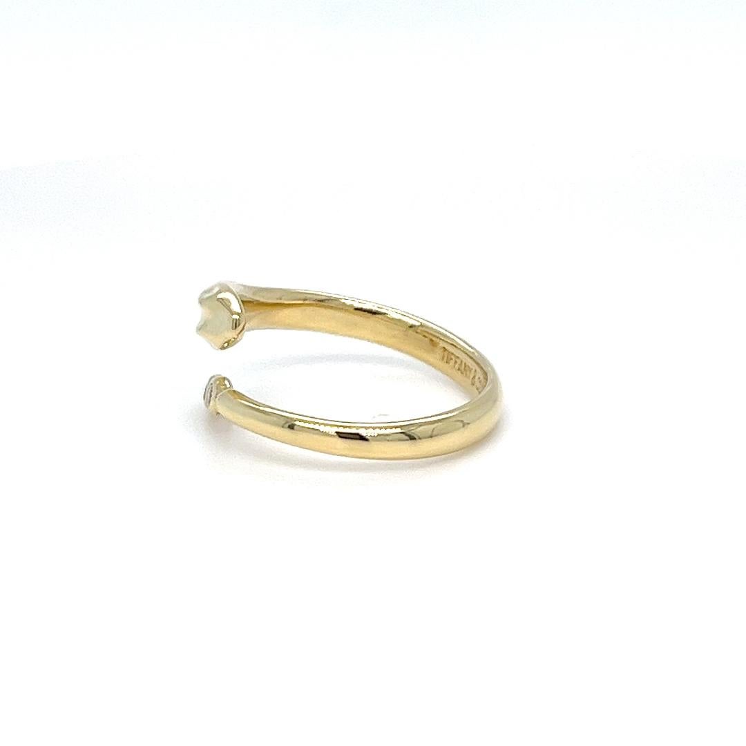 Tiffany and Co. by Elsa Peretti 18 karat yellow gold snake ring featuring 3 round brilliant cut diamonds of VS clarity and G color totaling 0.03 carats. $2,800 MSRP. Open adjustable size design. Finished weight is 4.4 grams. Made in Spain. Includes