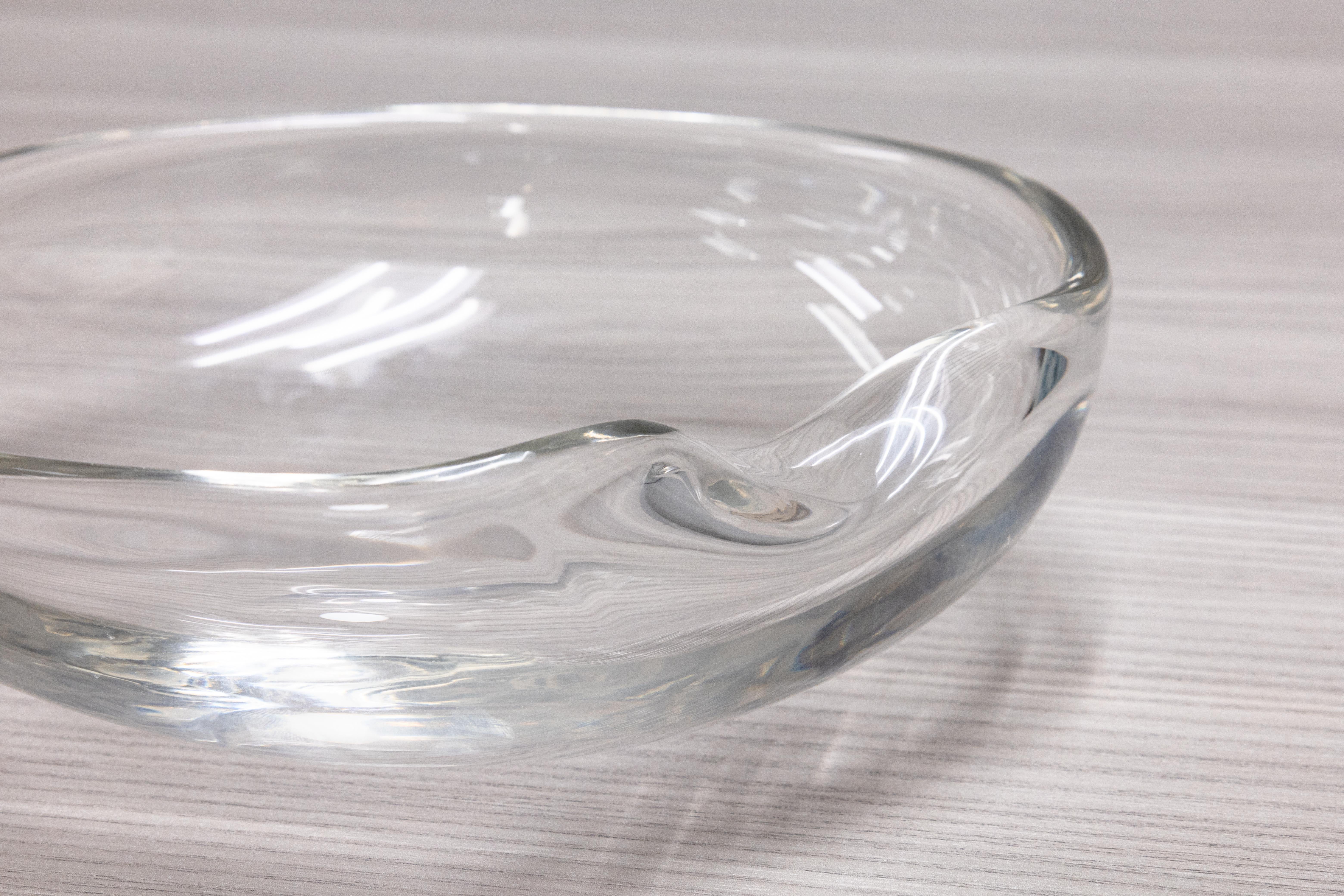 A gorgeous hand blown glass bowl designed by Elsa Peretti for Tiffany & Co. This piece, known as the “Thumbprint Bowl”, features a lovely classic design with a sloped side that fits nicely into your thumb. This piece is signed on the bottom, and