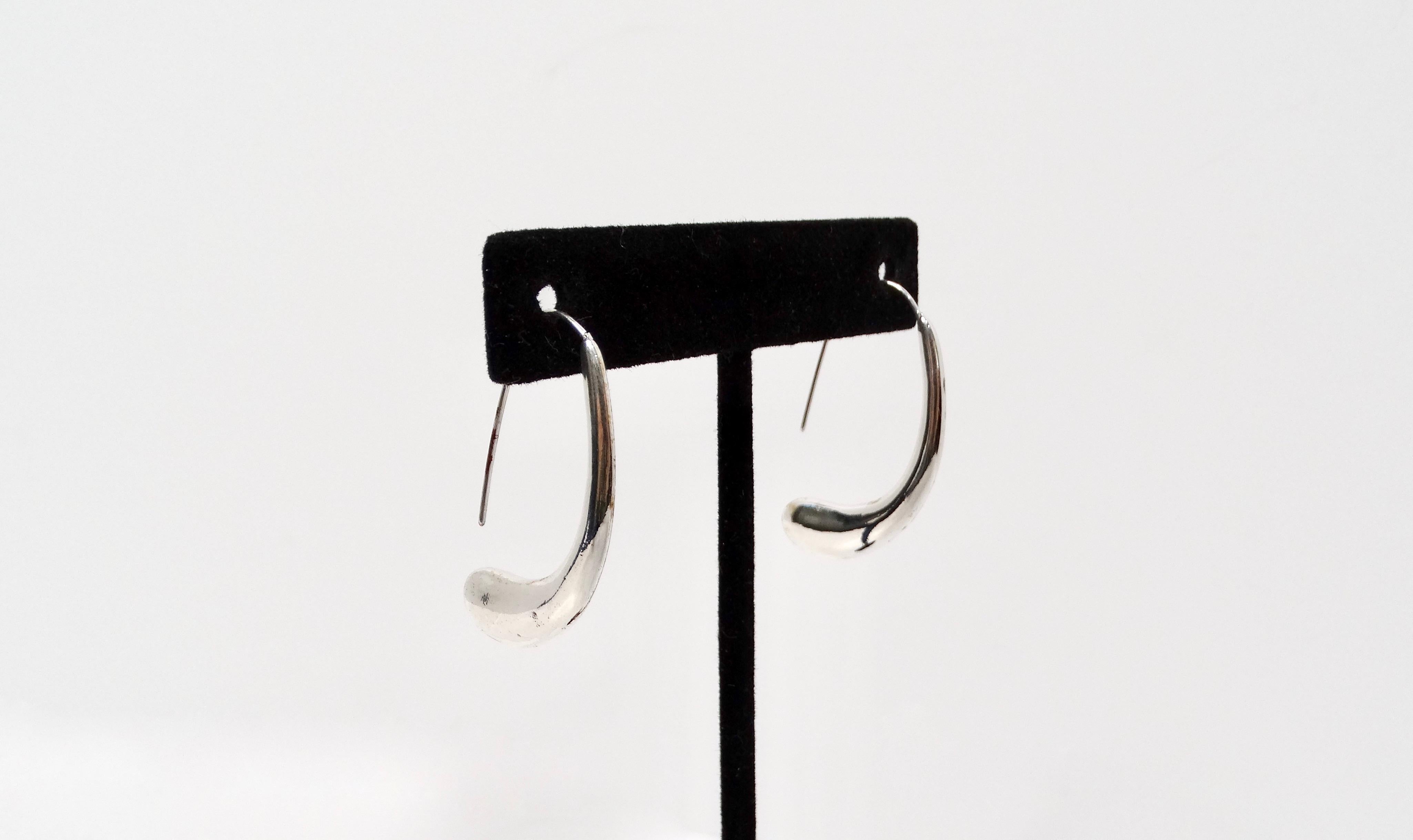 The Elsa Peretti for Tiffany & Co. 2005 Elongated Teardrop Sterling Silver Earrings are a stunning embodiment of modern elegance and minimalism. With their sleek and fluid design, these earrings gracefully embrace the natural contours of the body,