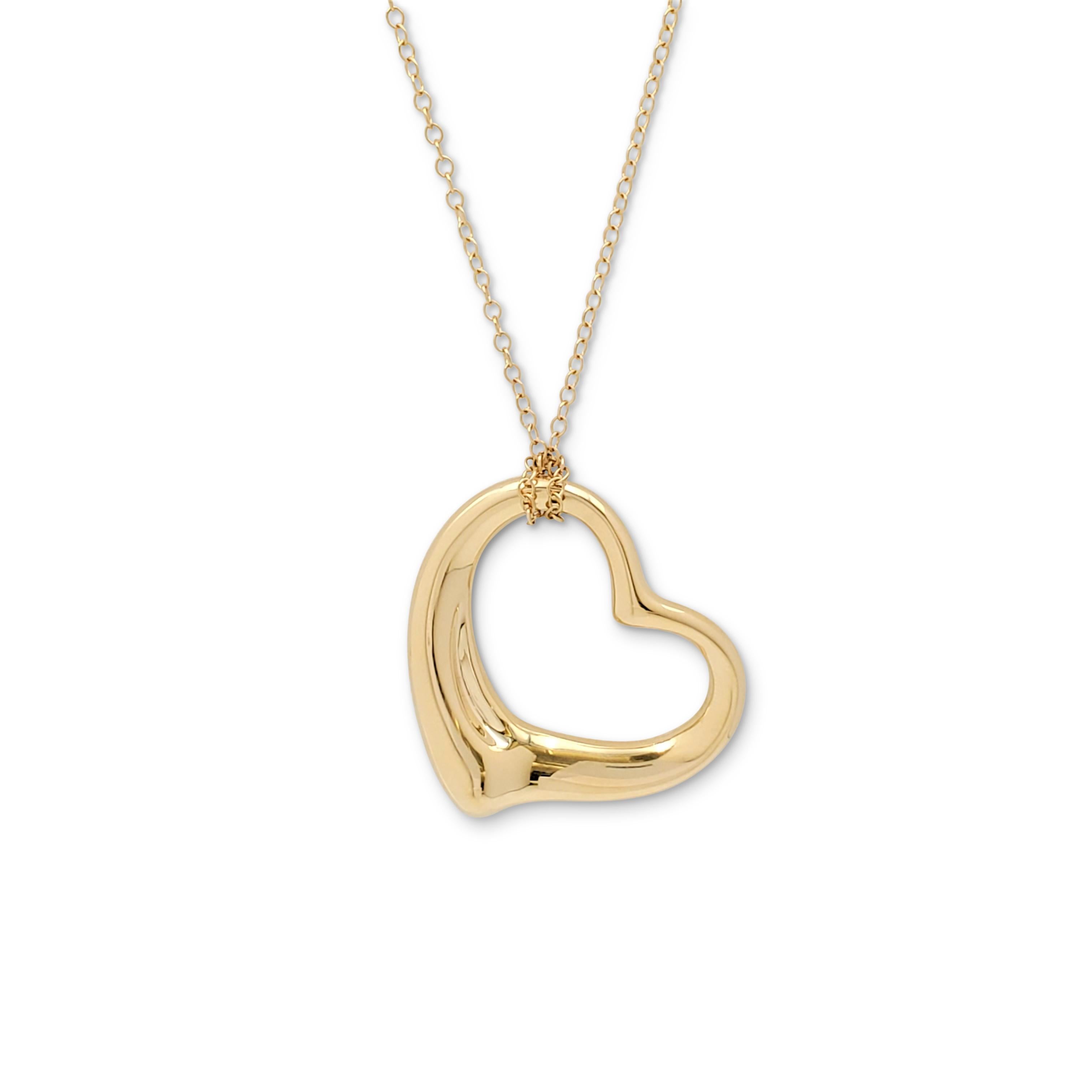 Authentic Elsa Peretti for Tiffany & Co. 'Open Heart' pendant crafted in 18 karat yellow gold. The pendant measures 35 x 35mm and hangs from an original 18 karat yellow gold chain which measures 30 inches in length. Signed Tiffany & Co., Elsa