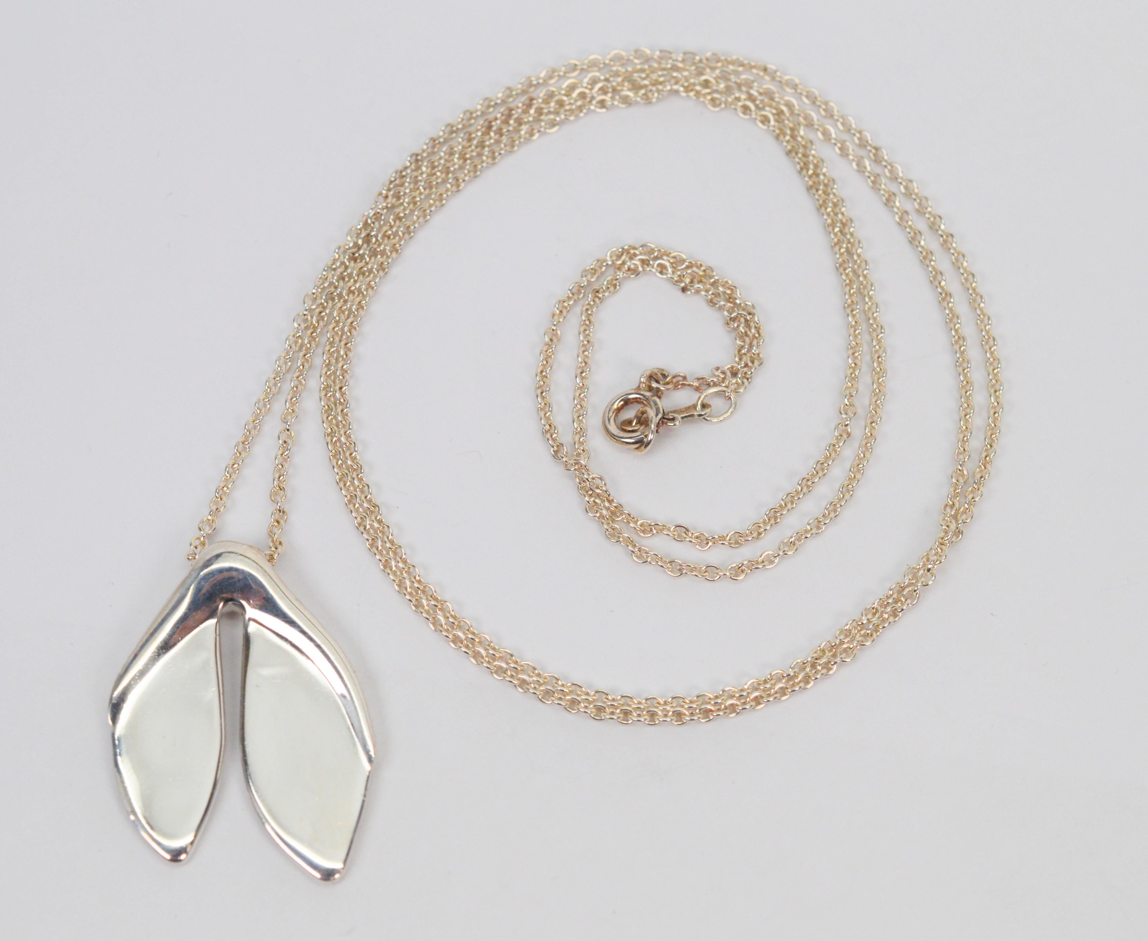 Vintage Tiffany & Co., suspended on a 31 inch sterling silver Peretti hallmarked chain is the icon Elsa Peretti's Whale Tail Leaf Pendant in .925 sterling. 
Presented on a longer length sterling silver chain, this piece is great to to wear with a
