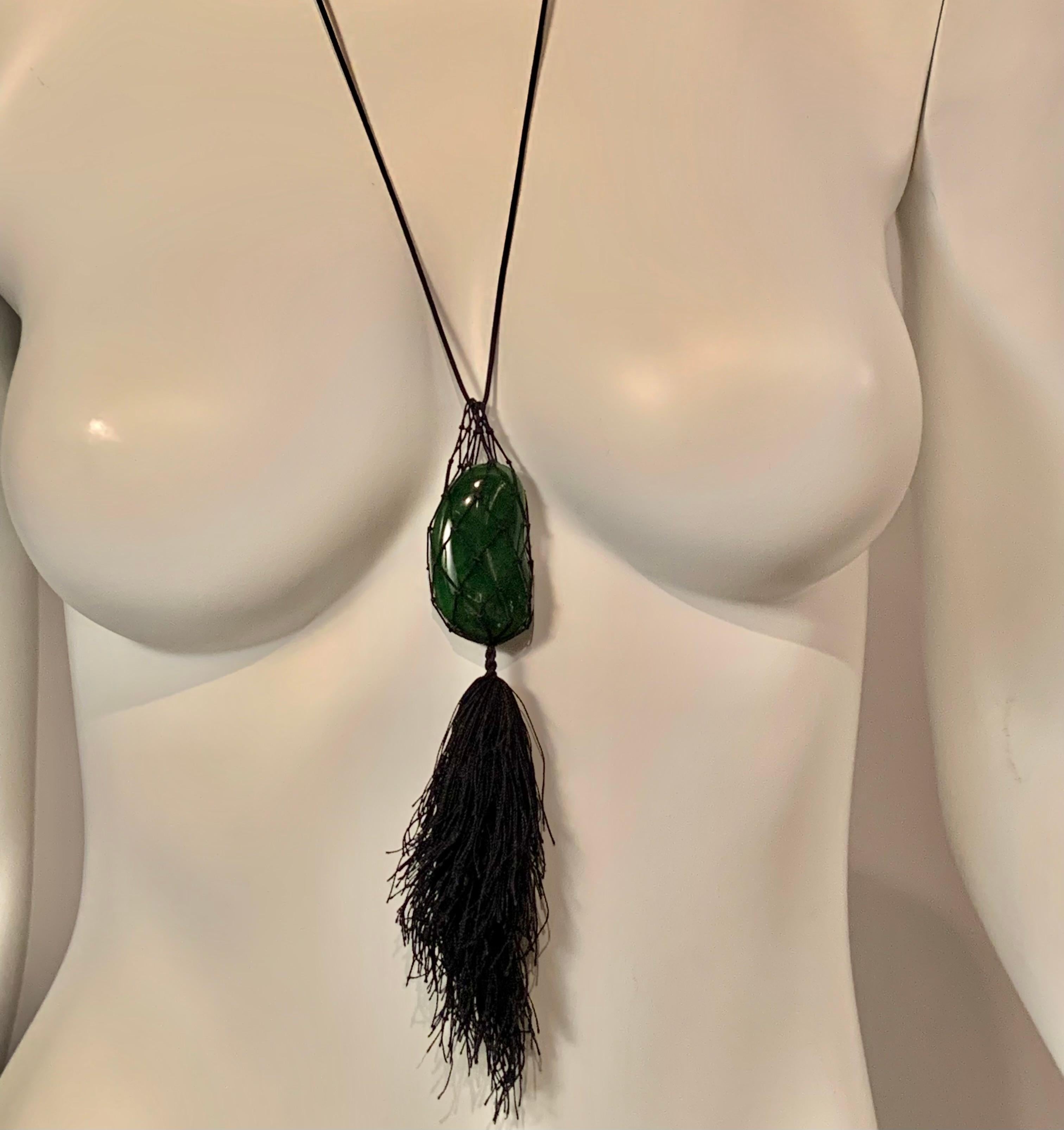 An unusual and extremely rare form for the iconic Elsa Peretti bean, this large jade bean is cradled in a hand woven black mesh bag. A large black tassel is suspended from the bag and a black cord completes the necklace. The silk cord, bag and