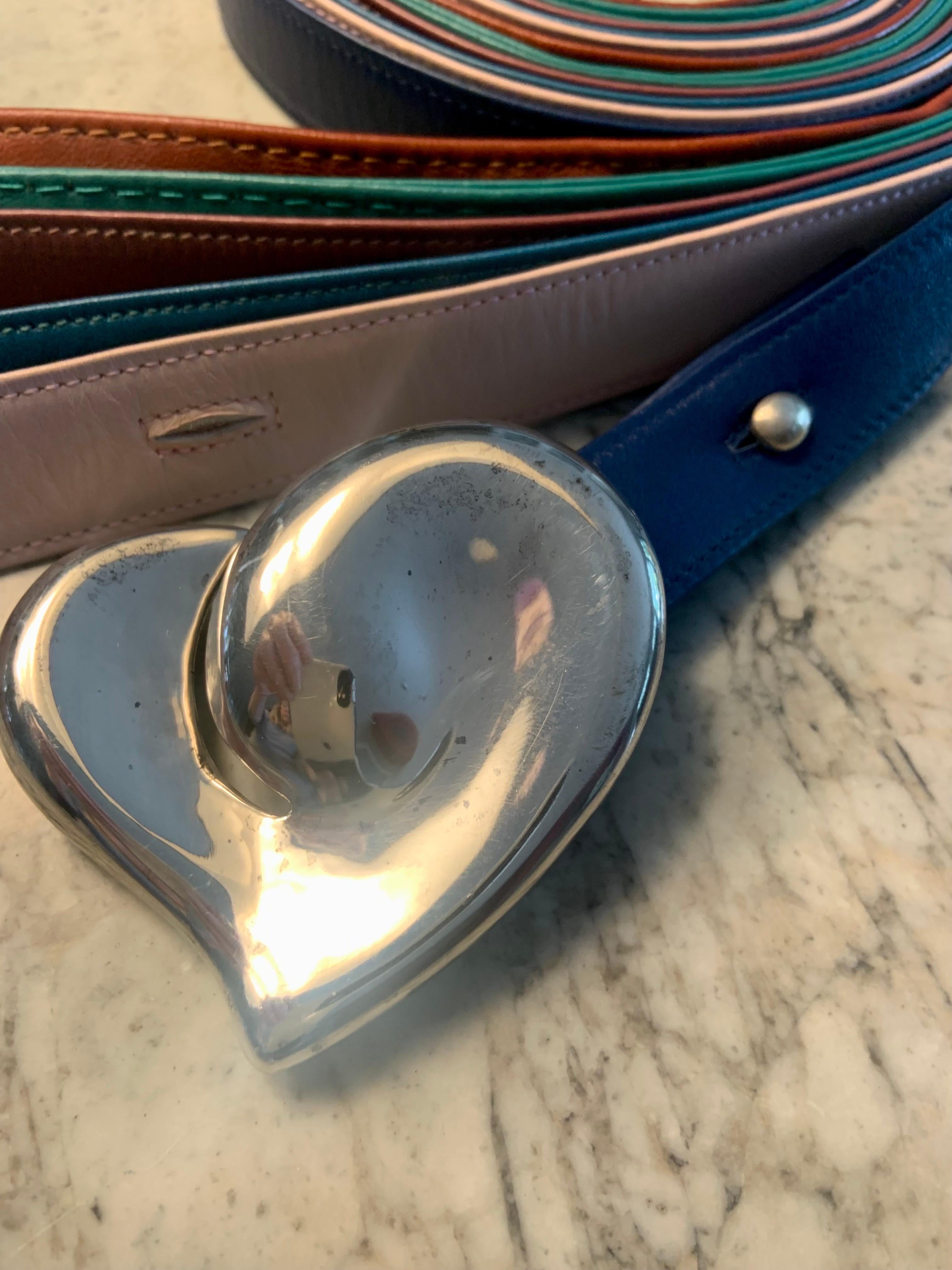 One of the early designs from Elsa Peretti this 1970's full heart buckle and button are fully marked Peretti, Tiffany & Co. and Sterling. The closure is an interesting and innovative design. 
 There are six leather belts, four of the belts are