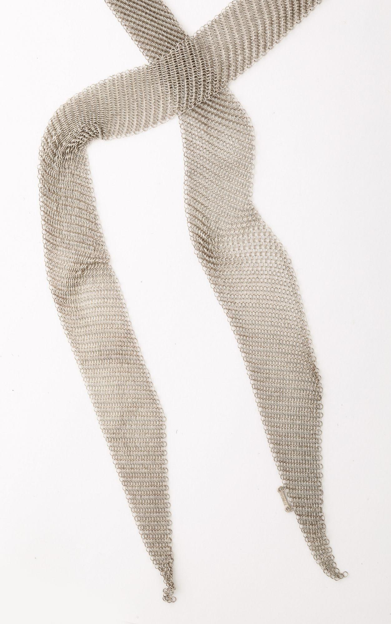 Este es un diseño de Elsa Peretti for Tiffany & Co. Collar Bufanda de Malla Silver.
Se trata de un collar largo y fluido elaborado en plata de ley fina con un intrincado diseño de malla tejida. La pieza se caracteriza por su textura suave, maleable