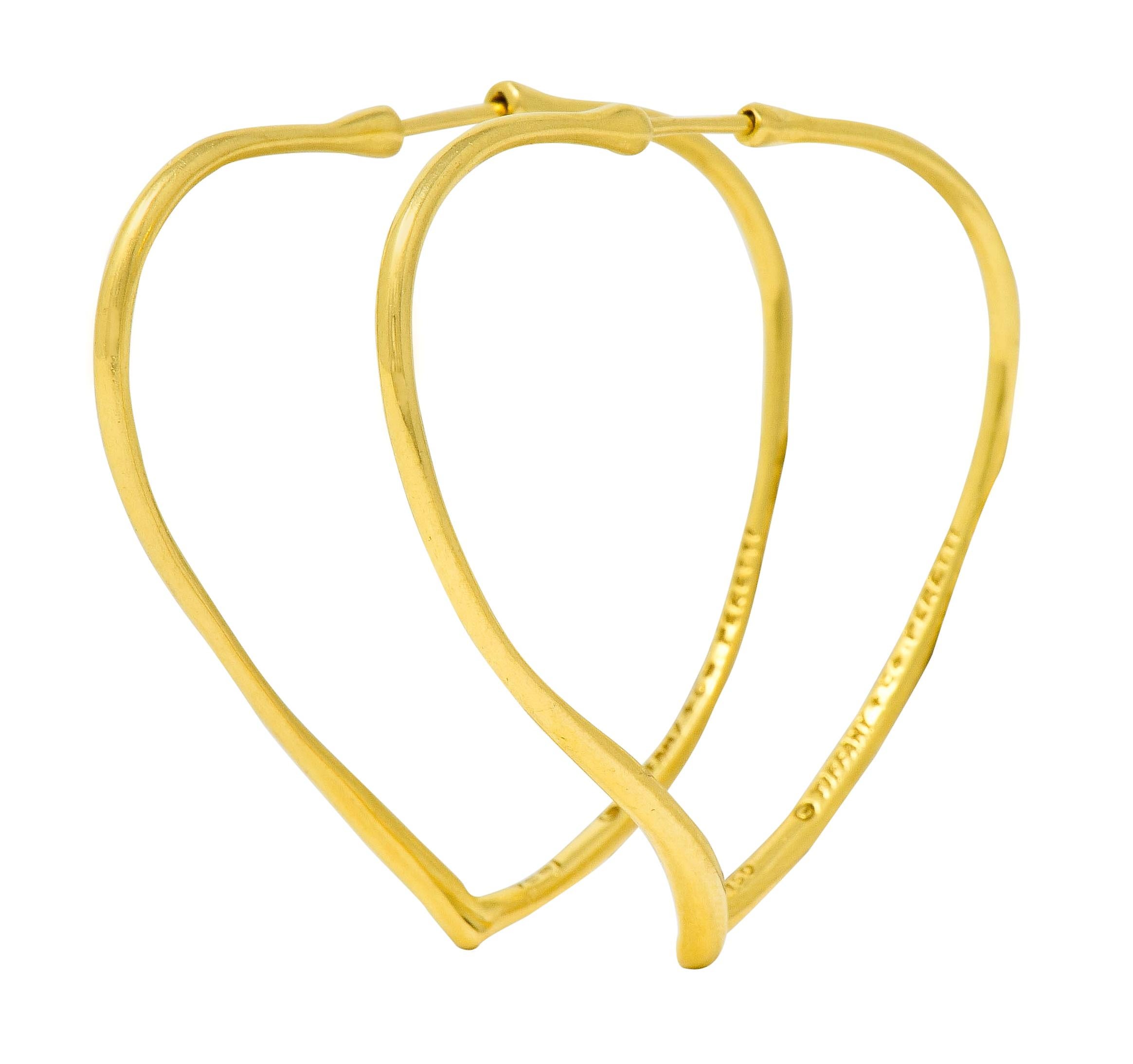 Hoop style earrings, organically shaped as a stylized open heart motif

With broad shoulders and fancifully torqued to echo heart, terminating at its iconic point

Completed by concealed posts

Both signed Tiffany & Co. Peretti and stamped 750 for