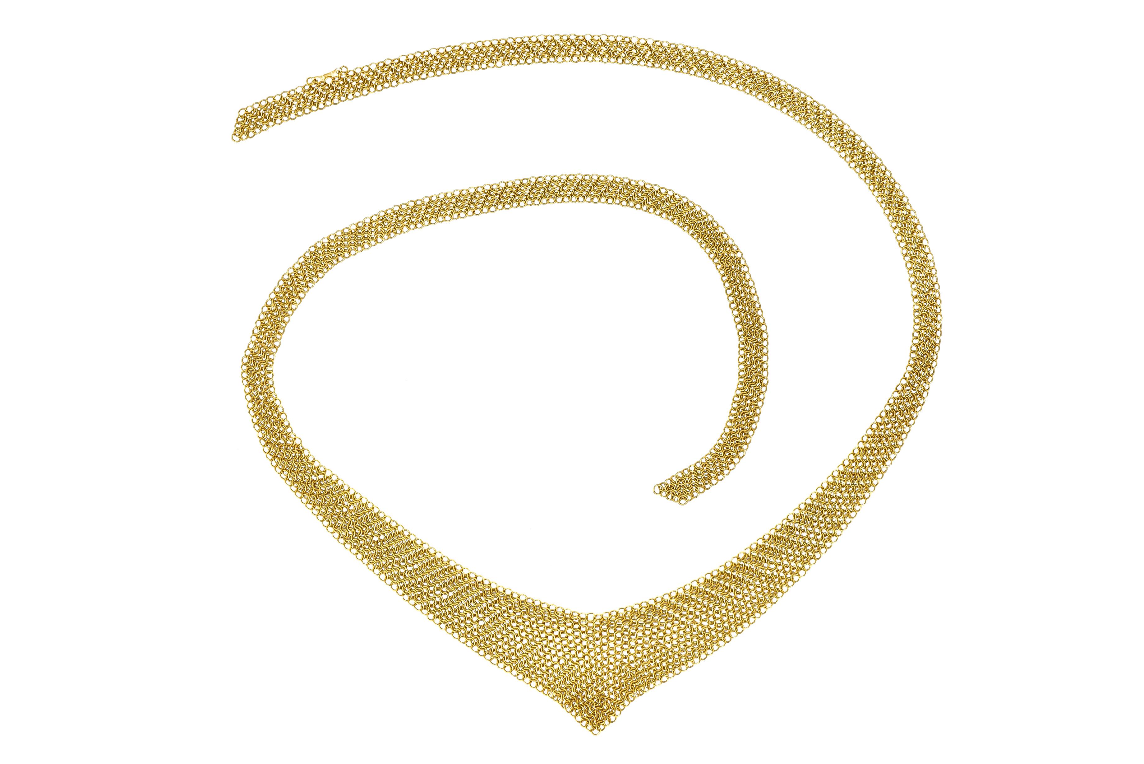 Scarf chain necklace is comprised of fine circular links woven together

Malleable mesh that graduates into a chevron point

Logo link is stamped 750 for 18 karat gold

Logo link is signed Peretti and T & Co.

Circa: 1990s

Length: 26 1/2