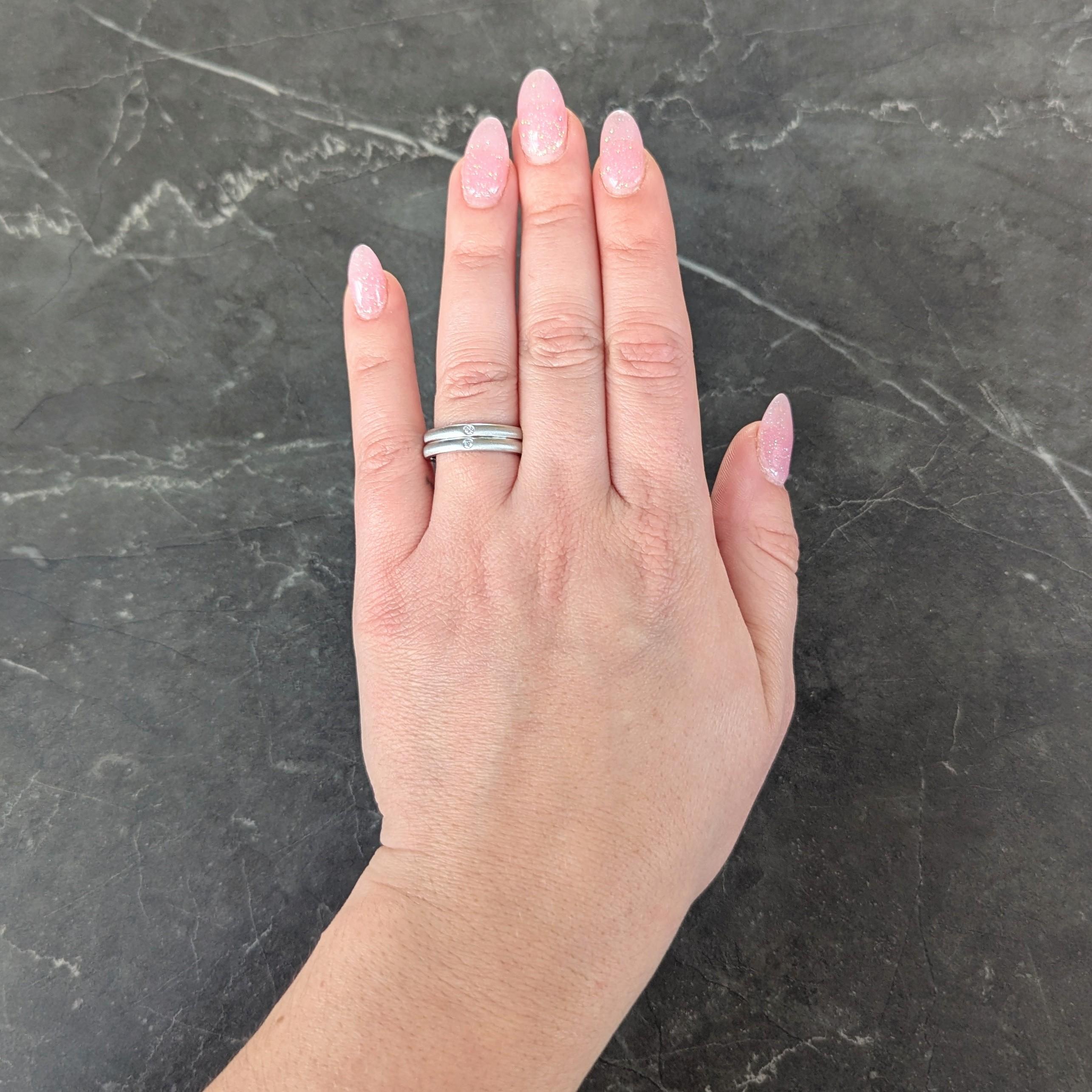 Designed as two stacked bands with a brushed matte finish
Each flush set with a round brilliant cut diamond
Weighing approximately 0.06 carat total
Eye clean and bright
Stamped for platinum
Fully signed for Elsa Peretti for Tiffany & Co.
Circa: