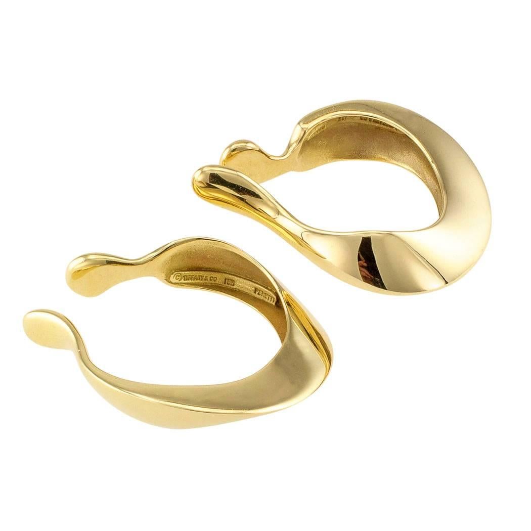 Elsa Peretti Tiffany & Co 18-karat gold ear cuffs. They are meant to be worn encircling and gripping the hollow of the ear. Part of the fun is that they can both be worn on the same ear, towards the side or vertically. They are different from other
