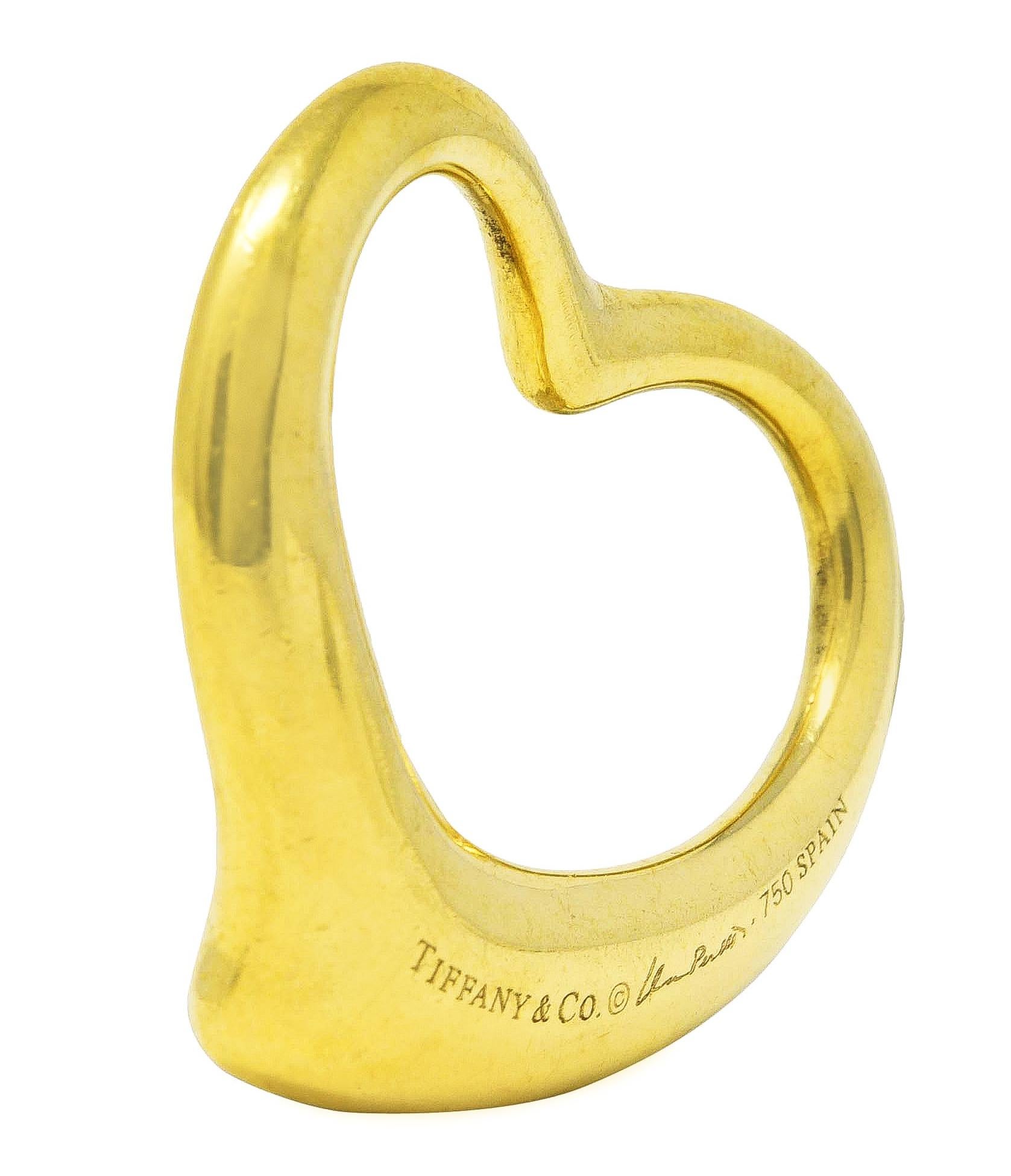 Pendant is designed as the stylized outline of a heart. With flowing contoured gold and a high polished finish. Stamped 750 for 18 karat gold. Fully signed Elsa Peretti Tiffany & Co. Spain. Circa: Late 20th century. Measures: 1 1/4 x 1 3/8 inches.