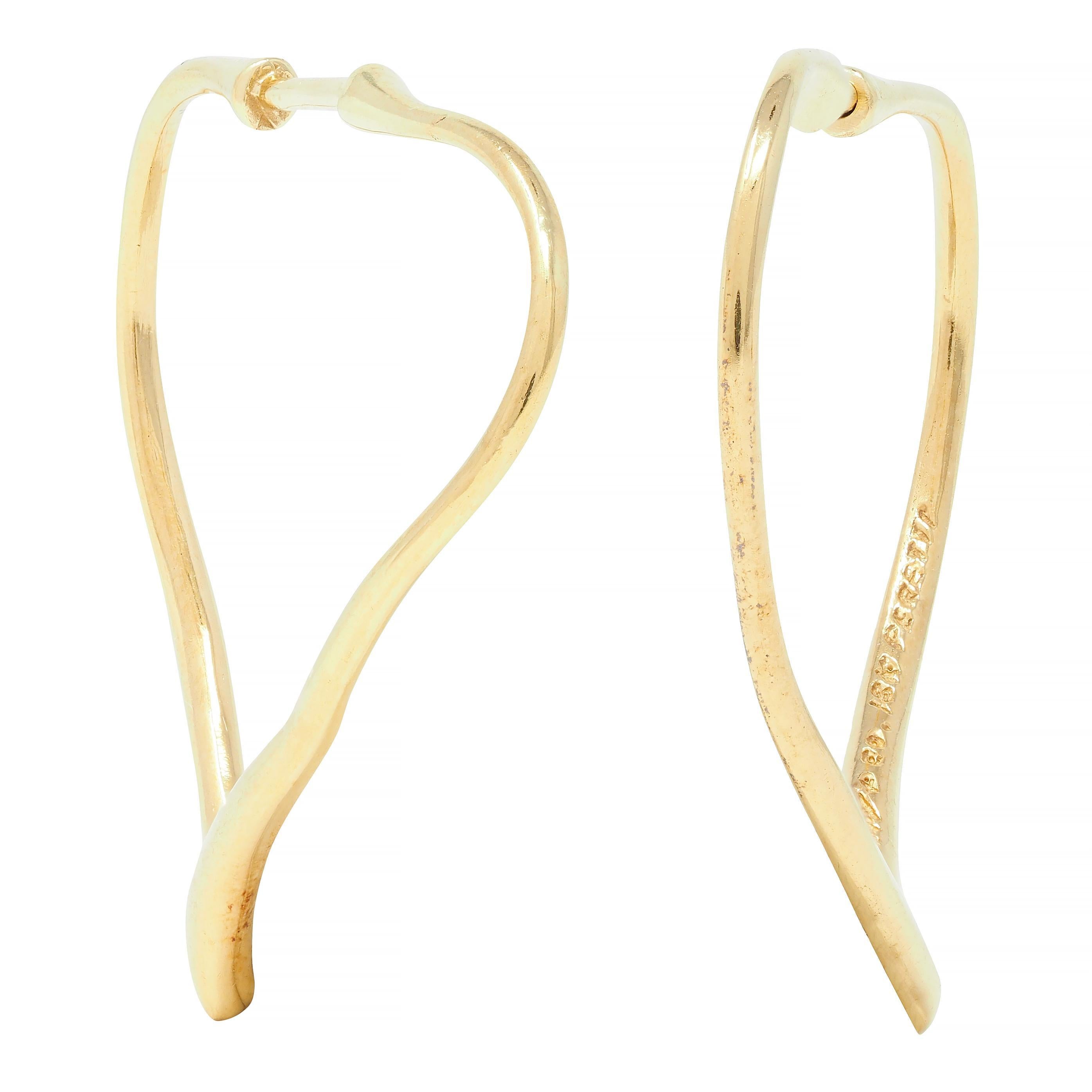 Designed as a stylized heart-shaped contour 
Sinuous with sleek minimal design 
Completed by posts with press in catch 
Stamped for 18 karat gold
Fully signed for Elsa Peretti and Tiffany & Co. 
Circa: 1990s
Measures: 1 1/4 x 1 3/8 inches
Total
