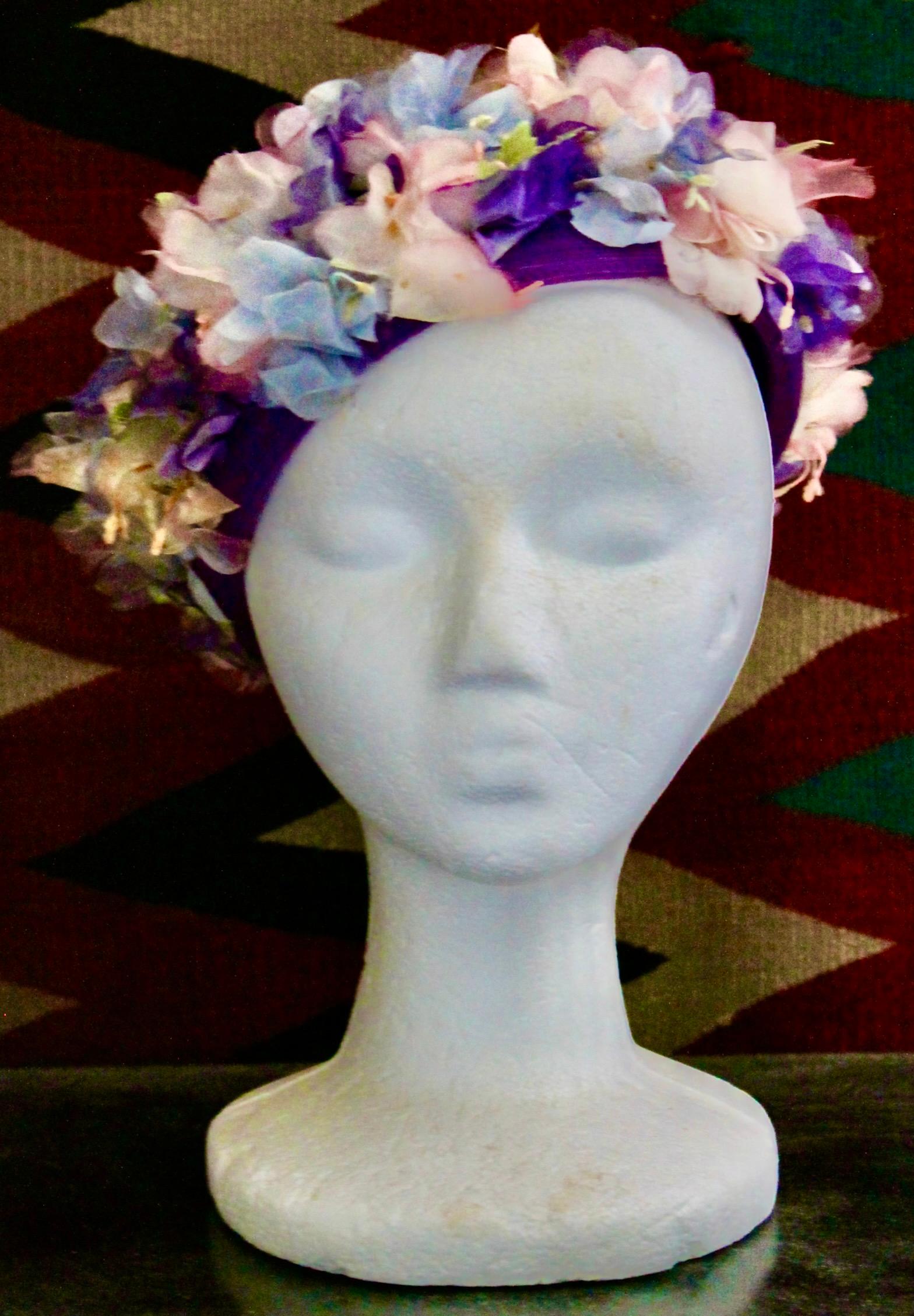 Elsa Schiaparelli Spring Hat with wreath of pastel silk flowers around the edge.
Wrapped straw, silken floss flowers, hand sewn attached to netting frame.
Outside measure 10