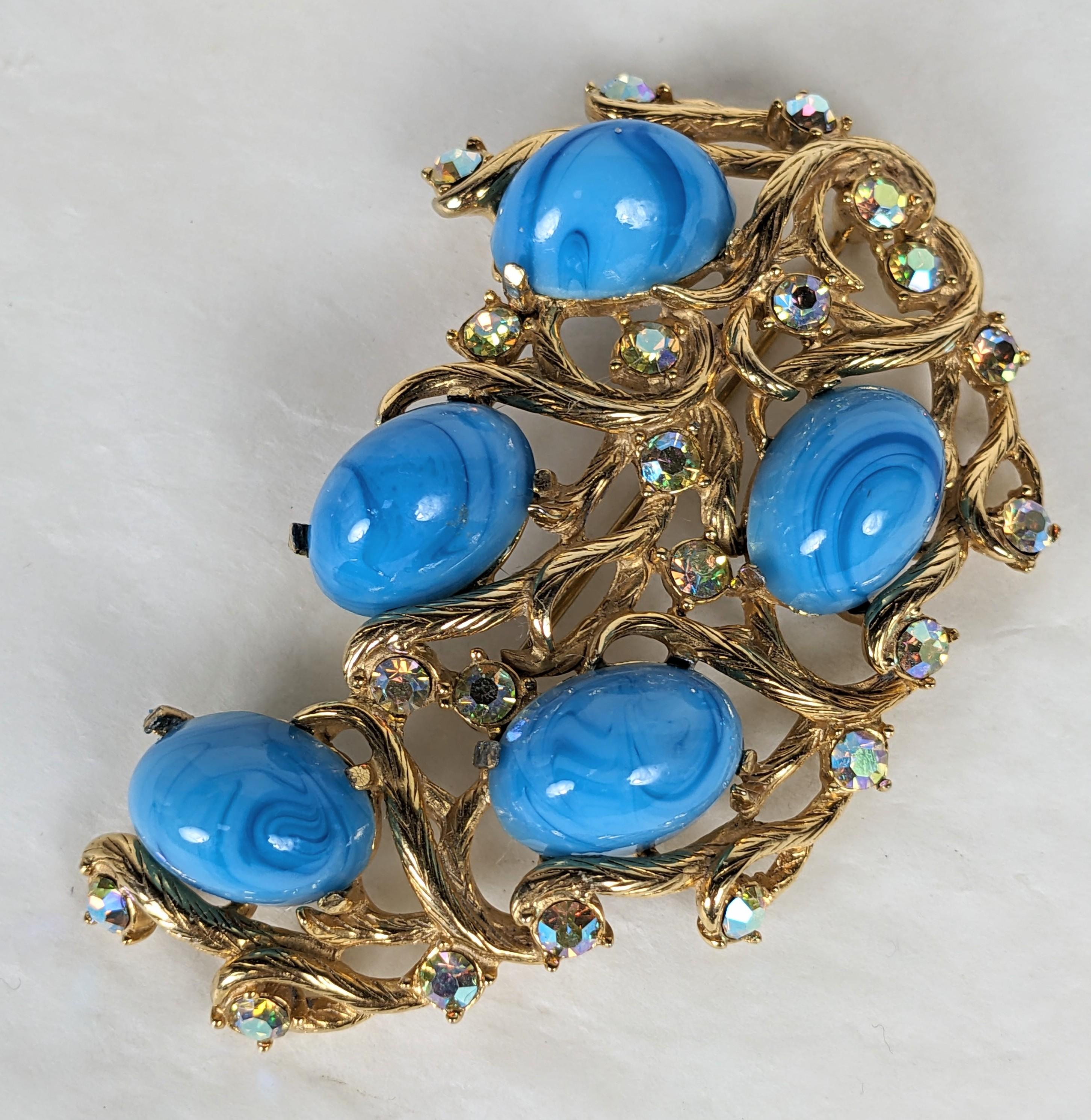 Elsa Schiaparelli  Broche de style néo-baroque composée d'un motif de vigne feuillue en métal doré texturé avec de larges cabochons ovales en fausse turquoise tibétaine et des facettes en verre irisé rose/bleu/or.  strass. Excellent état, Signé. L