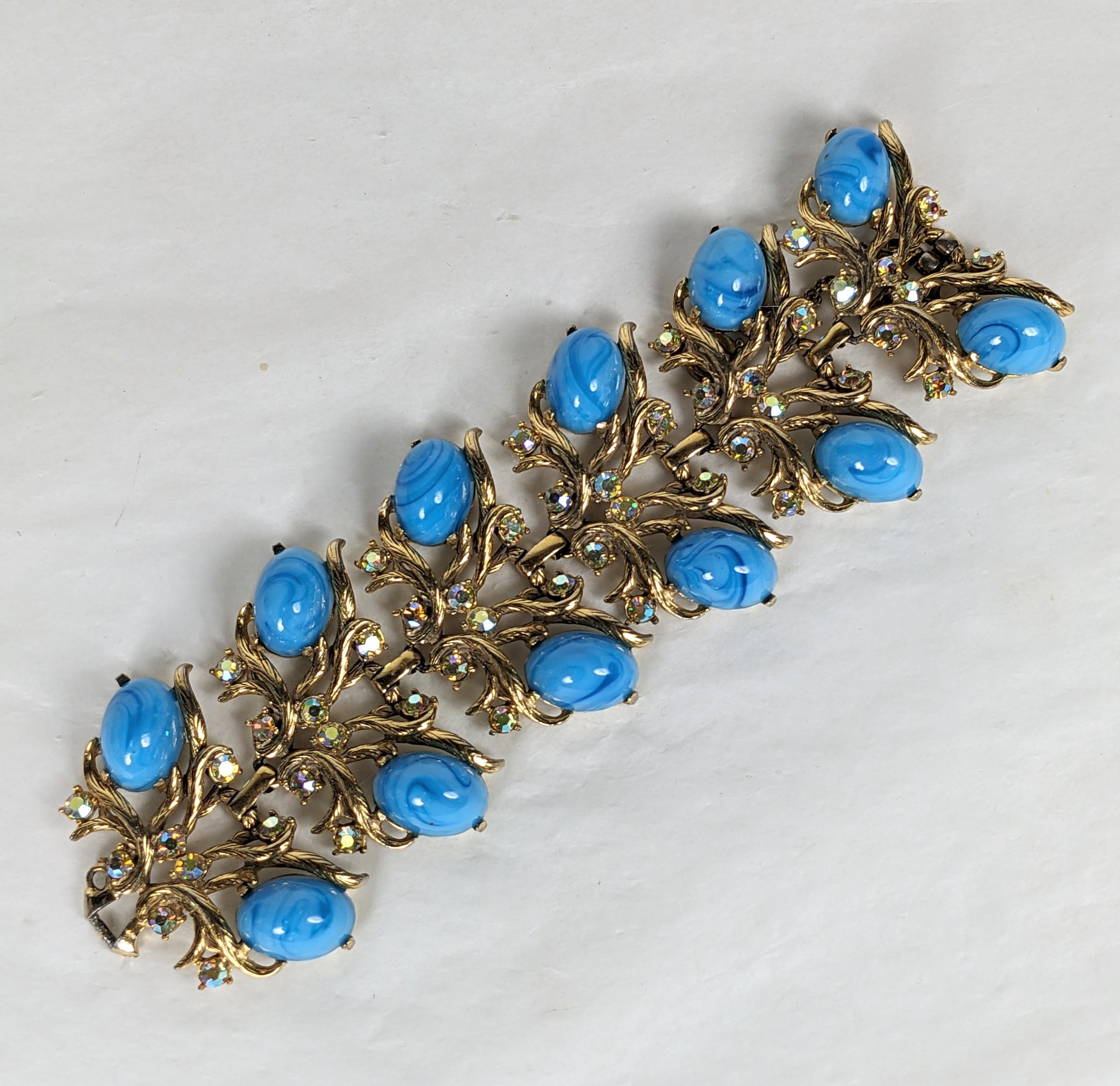 Elsa Schiaparelli Baroque revival wide bracelet composed of leafy vine motif  textured gilt plate base metal with faux Tibetan turquoise oval cabochons and iridized Aurora pink/blue/gold faceted  rhinestones.
Excellent Condition, Signed. L 7.50