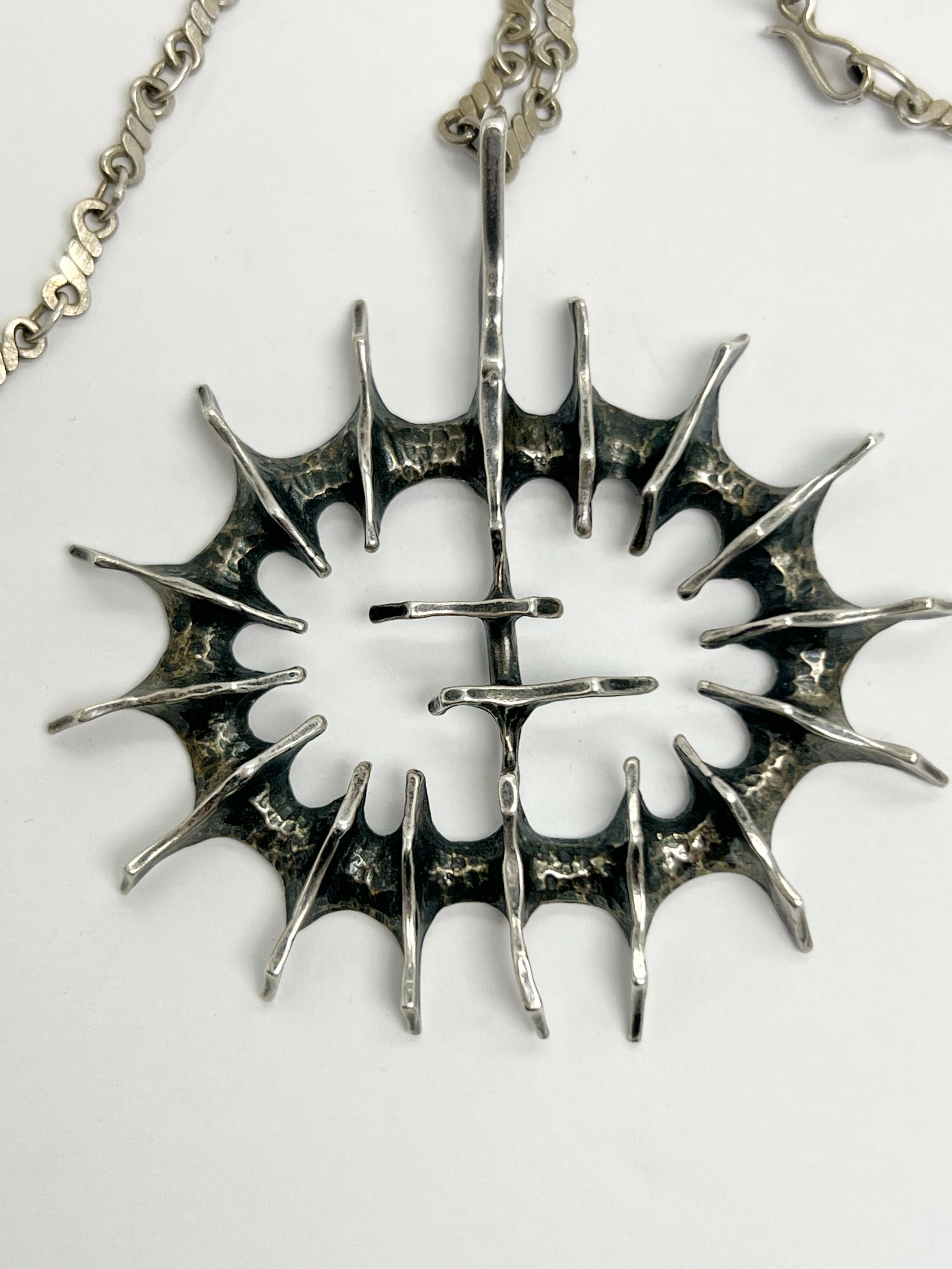 A sterling silver chain with pendant. Chain is sterling as well and 24” long