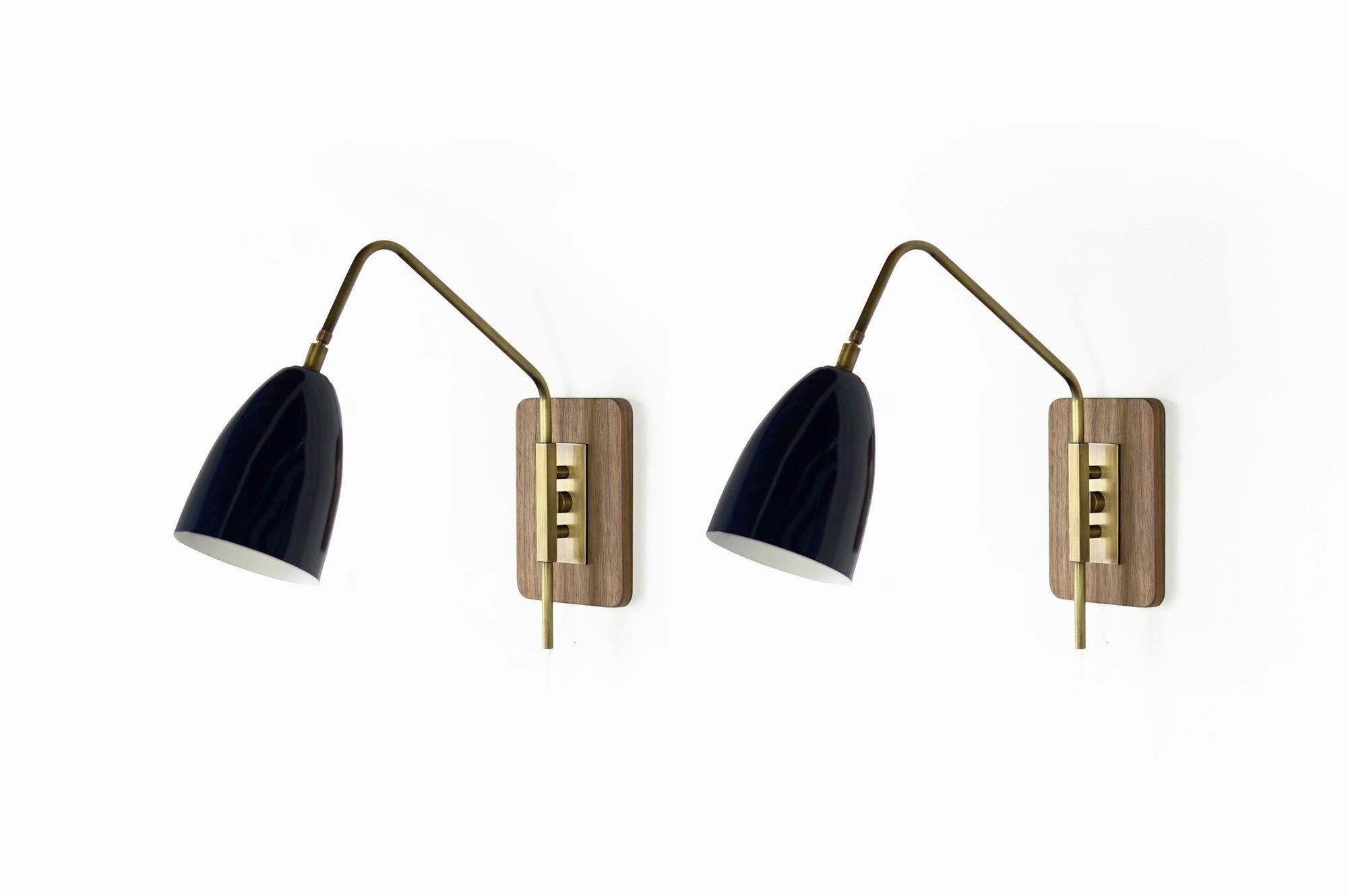 The Elska Wall Mount Reading Lamp is a stylish and functional fixture that draws inspiration from Scandinavian, Danish, and Italian Mid-Century Modernism. Its walnut backplate and architectural brass fittings create a visually stunning design