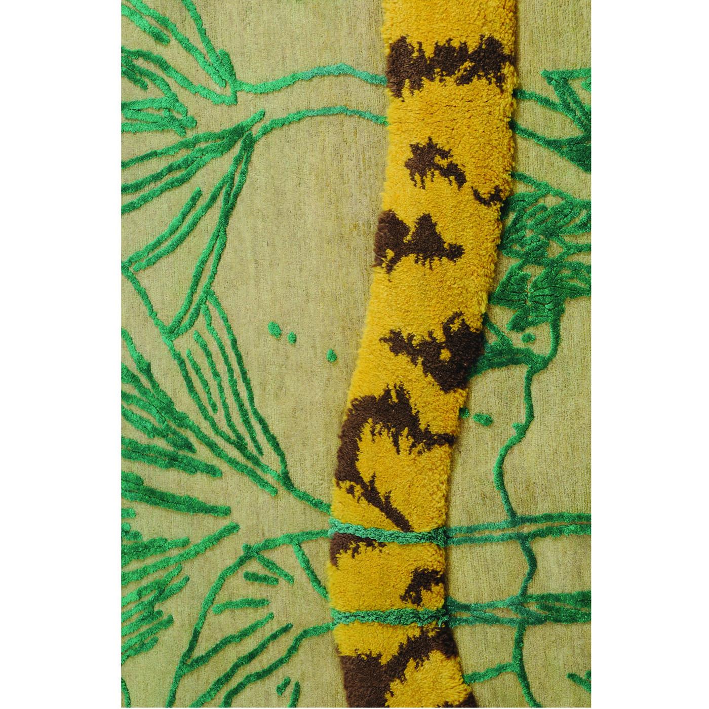 This contemporary rectangular rug will make a striking statement when placed in any room in the home. The background is in ivory wool and bares a green hand knotted linear leaf-like pattern representative of a jungle. In the central section of the