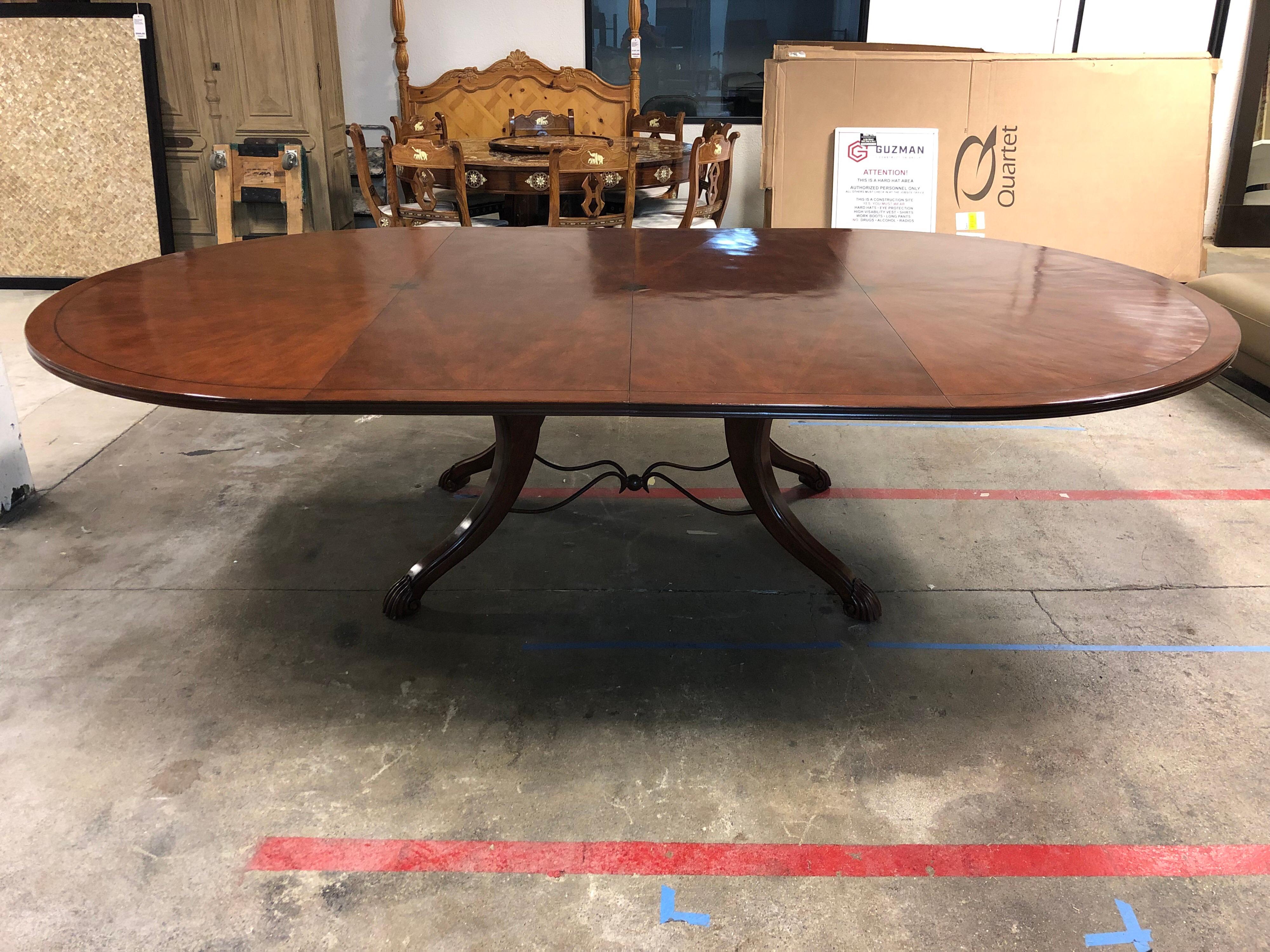 Galloway dining table by Emanuel Morez. The table is 70 inches round with a sunburst design on top. The finish is a #210 Deep Cherry on Cherry standard Inlay and destressing. Accompanied with two 24 inches centre extensions. Four curved claw foot