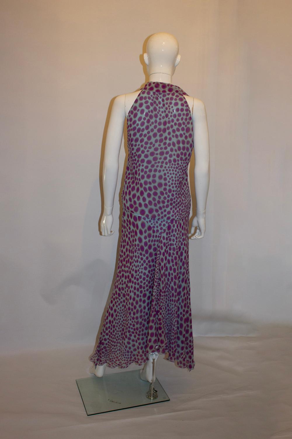 Un ensemble en soie amusant signé Emanuel Ungaro . Le haut et la jupe sont en soie turquoise avec des taches violettes et sont doublés. La jupe est une taille 38, avec un volant au centre et une ouverture zippée sur le côté. Mesures : Taille 29'',