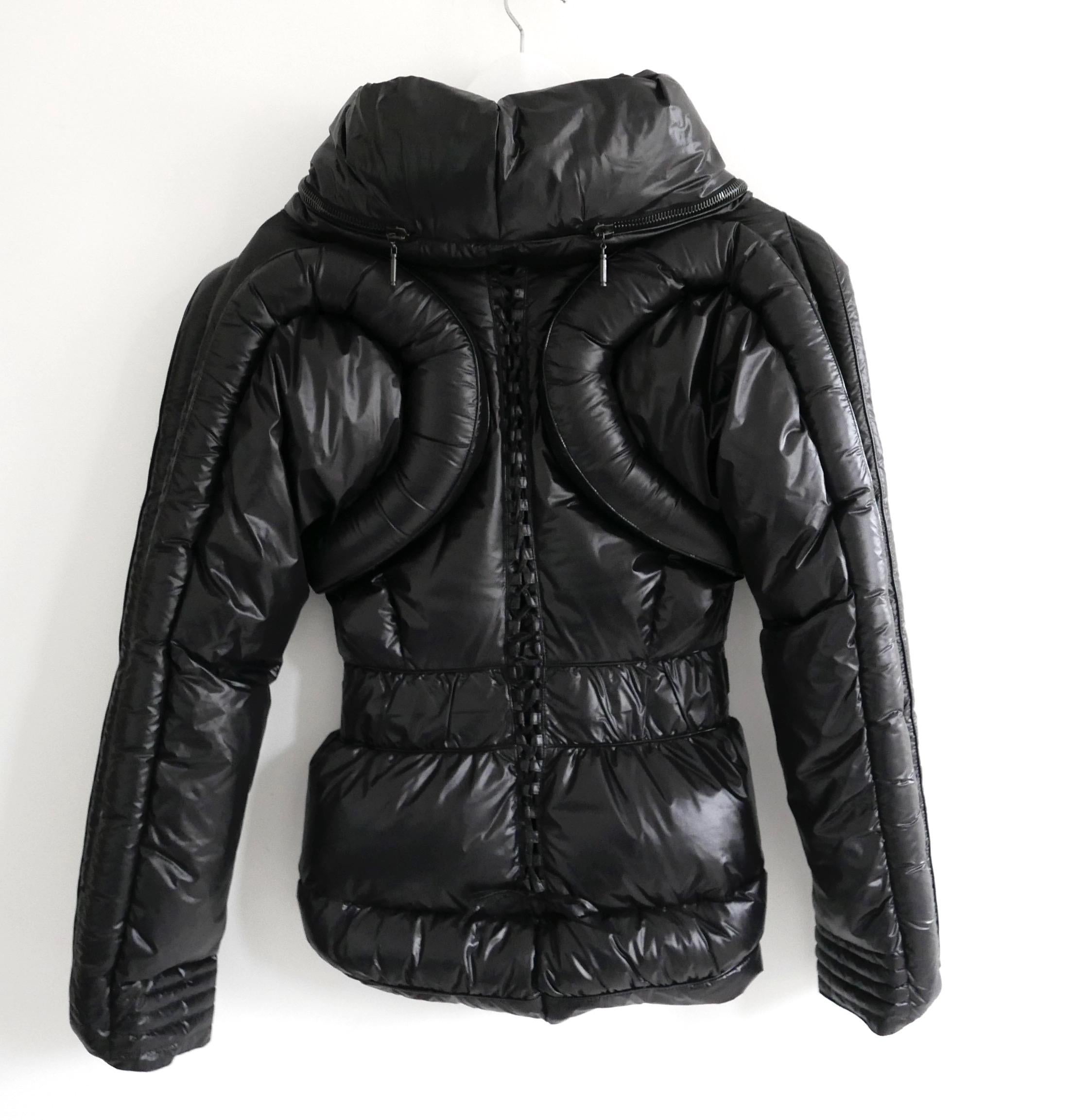 Absolutely incredible vintage Emanuel Ungaro puffer coat. From the Fall 2007 collection (look 11) and in immaculate, unworn condition. Made from soft, glossy black nylon with masses of chunky, black enamelled hardware. Has a superbly sculptural
